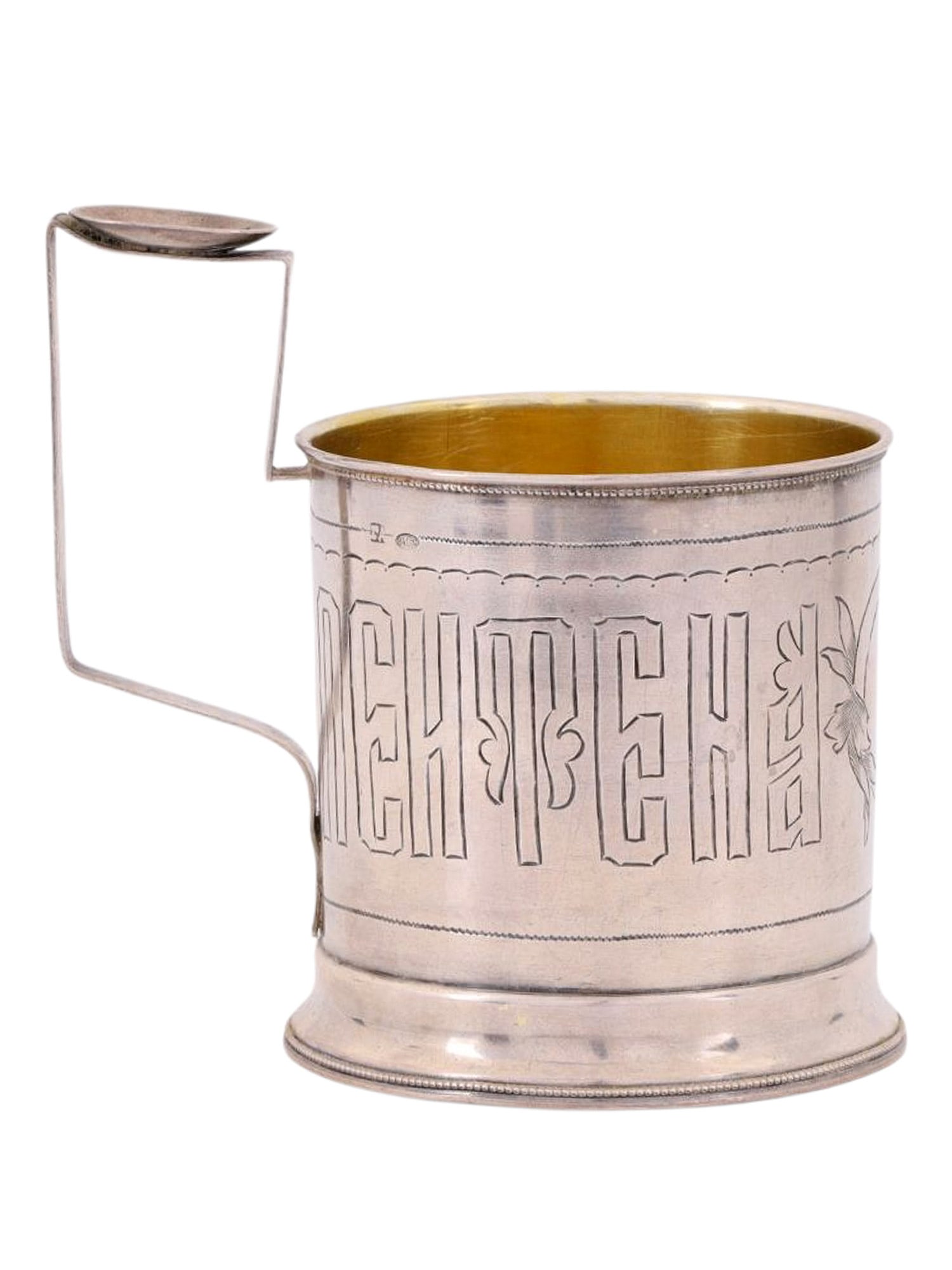 A RUSSIAN PARCEL-GILT SILVER TEA GLASS HOLDER, WORKSHOP OF GERASIM AFANASYEV, EARLY 20TH CEN.: A cylindrical tea glass holder with a rectangular handle, featuring a central engraved medallion with floral decoration and the inscription “PEYTE NA ZDOROVYE” (Drink to Your Health) aroun