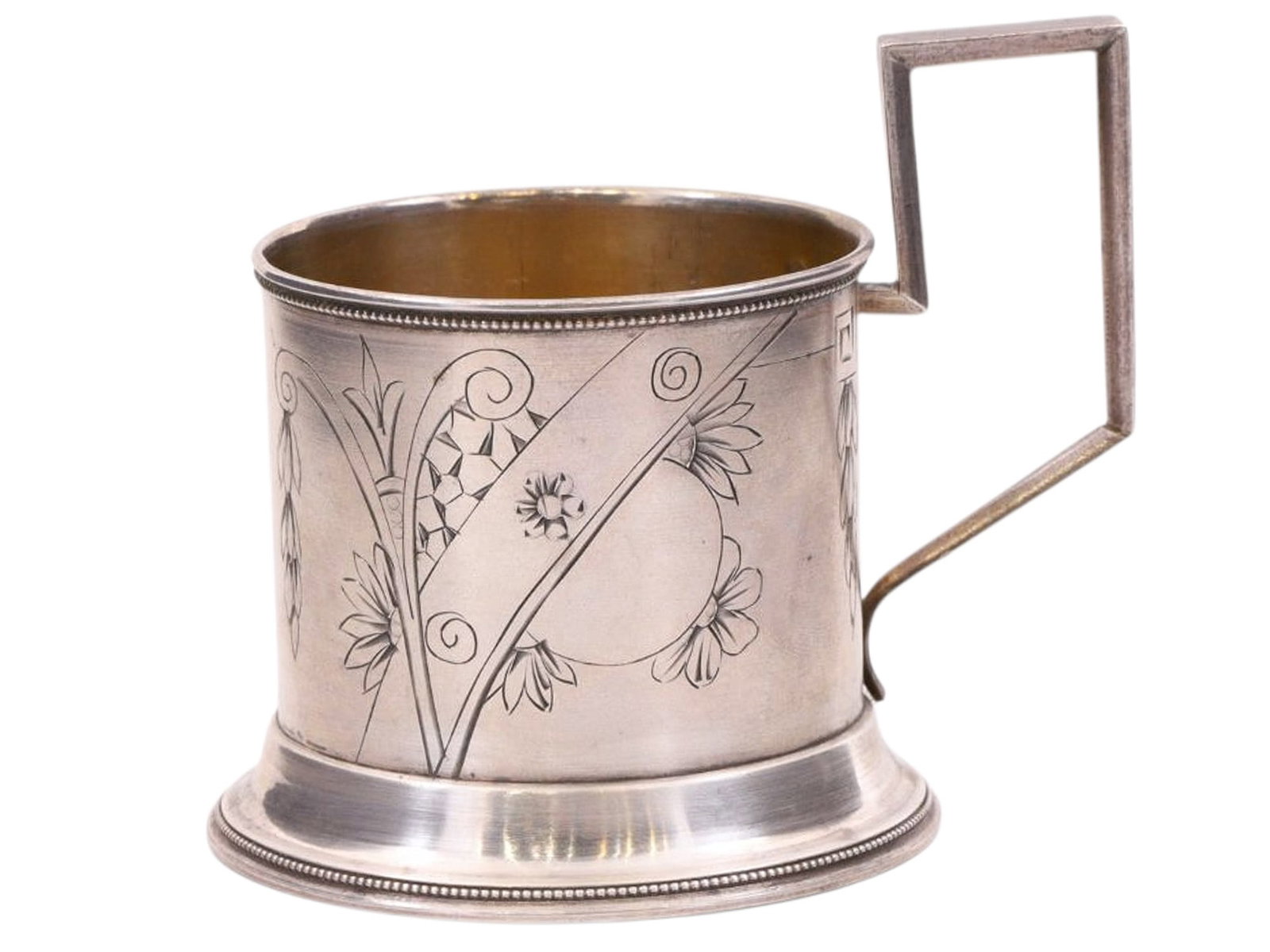 A RUSSIAN SILVER TEA GLASS HOLDER IN ART-NOUVEAU STYLE, C. 1890S: A simple cylindrical tea glass holder with a rectangular handle, featuring a minimalist Art Nouveau-style floral engraving. The upper and lower rims are decorated with a narrow beaded border. There ar