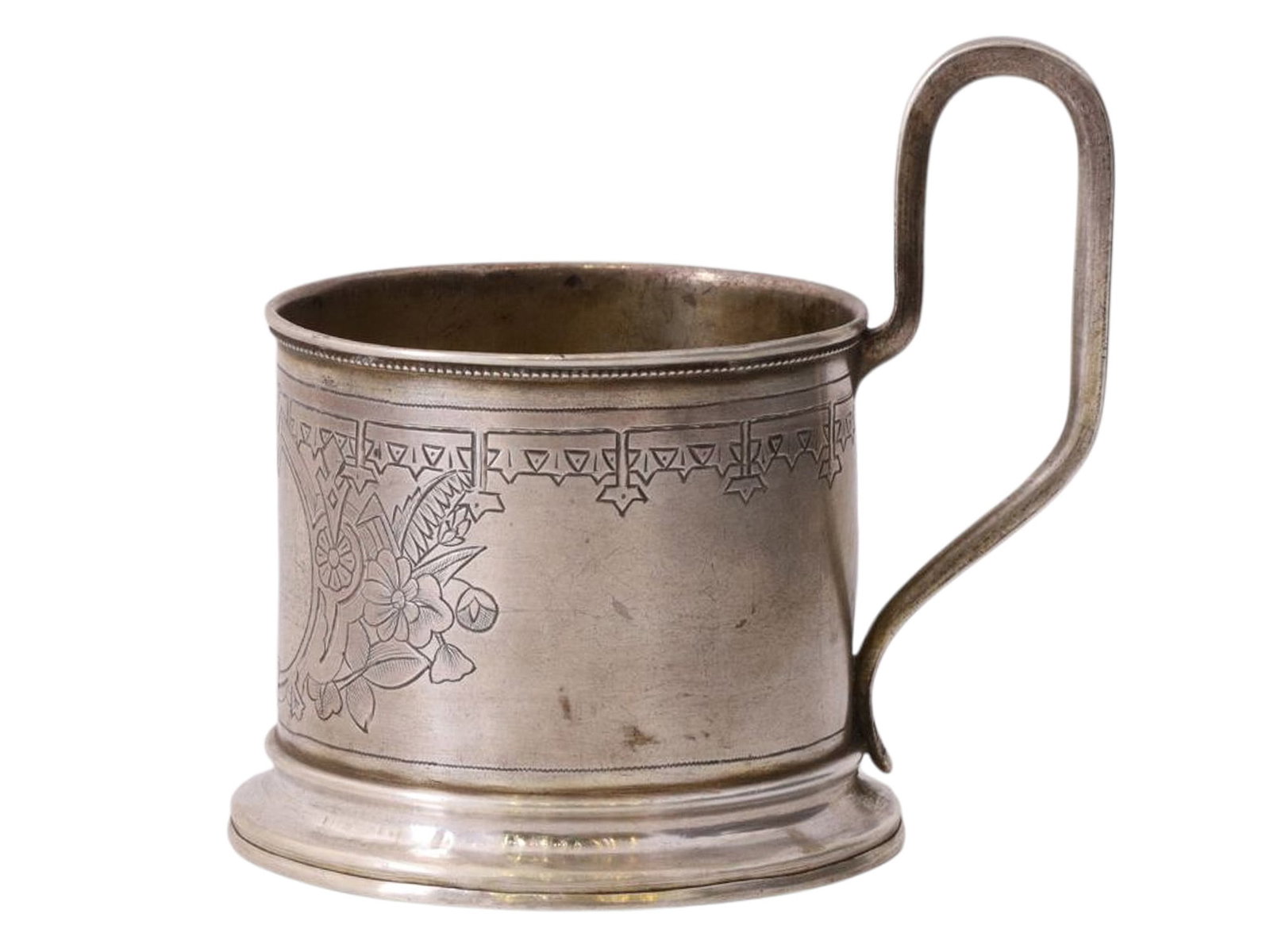 A RUSSIAN SILVER TEA GLASS HOLDER, VASILY IVANOV WORKSHOP, 1892: A cylindrical tea glass holder with a rounded handle, decorated with a simple engraved floral and geometric pattern and a beaded border along the upper rim. The central medallion bears no inscriptions