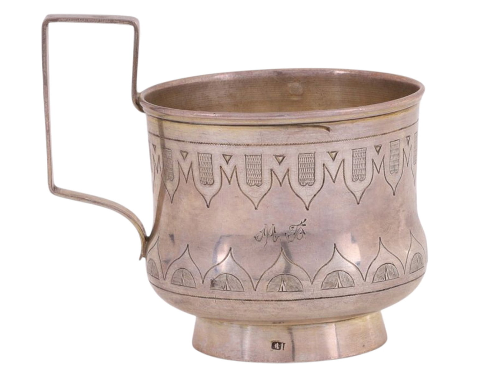 A RUSSIAN ENGRAVED SILVER TEAGLASS HOLDER, WORKSHOP OF IVAN SVESHNIKOV, 1878: A tea glass holder shaped like a rounded goblet with a rectangular handle, featuring an engraved ornamental design. A dedicatory inscription—“M.B. //19 2/VII 15 //Mom”—is engra