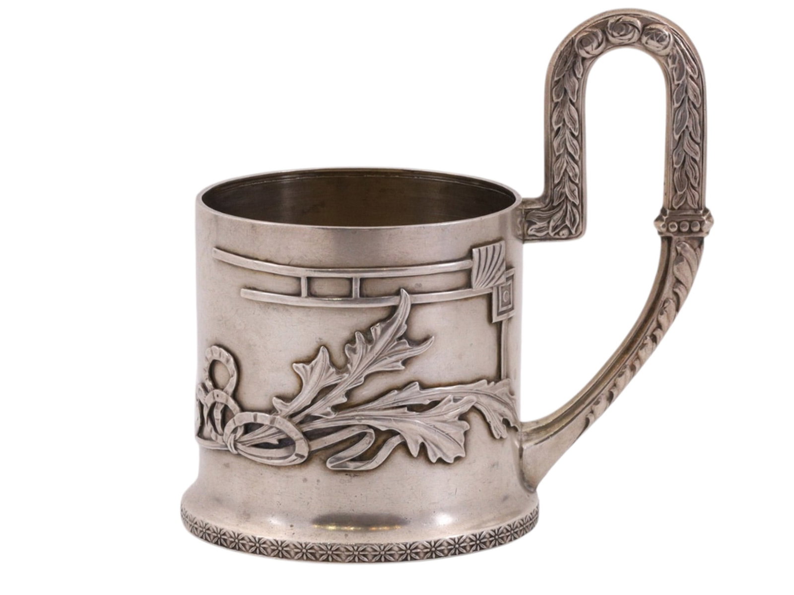 A RUSSIAN SILVER MILITARY PRESENTATION TEAGLASS HOLDER, 1917: Of cylindrical form with a slightly flared foot, the body applied with a cast and chased military trophy motif of crossed bugles, oak leaves, and ribbon ties beneath a geometric band suggestive of reg