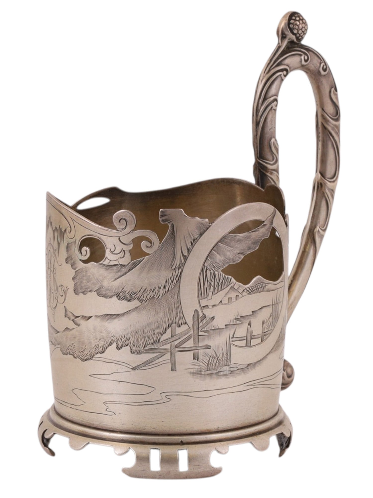 A RUSSIAN SILVER OPENWORK TEAGLASS HOLDER WITH LANDSCAPE SCENE, EARLY 20TH CENTURY: Of cylindrical form with a shaped, scalloped rim and raised on a pierced circular base, the body is finely worked in openwork and engraving, depicting a naturalistic landscape with a large bird in fli
