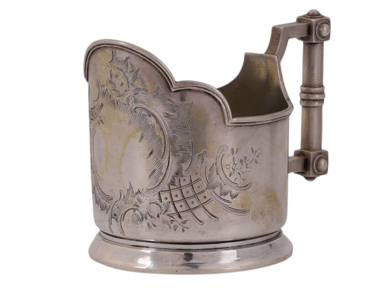 A RUSSIAN SILVER TEA GLASS HOLDER, MOSCOW, LATE 19TH / EARLY 20TH CEN.: A cylindrical tea glass holder with a perforated upper rim and a solid rectangular handle featuring elements of Russian Art Nouveau, decorated with a large engraved medallion bearing a floral motif an