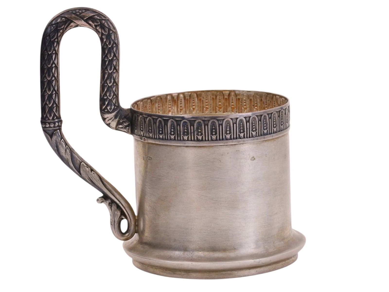A RUSSIAN SILVER TEAGLASS HOLDER WITH FOLIATE HANDLE: Of a cylindrical form with a rounded handle featuring a geometrical pattern.The upper rim, the body, and the base bear hallmarks: the assay mark "84" with a head in a kokoshnik facing right and a delt