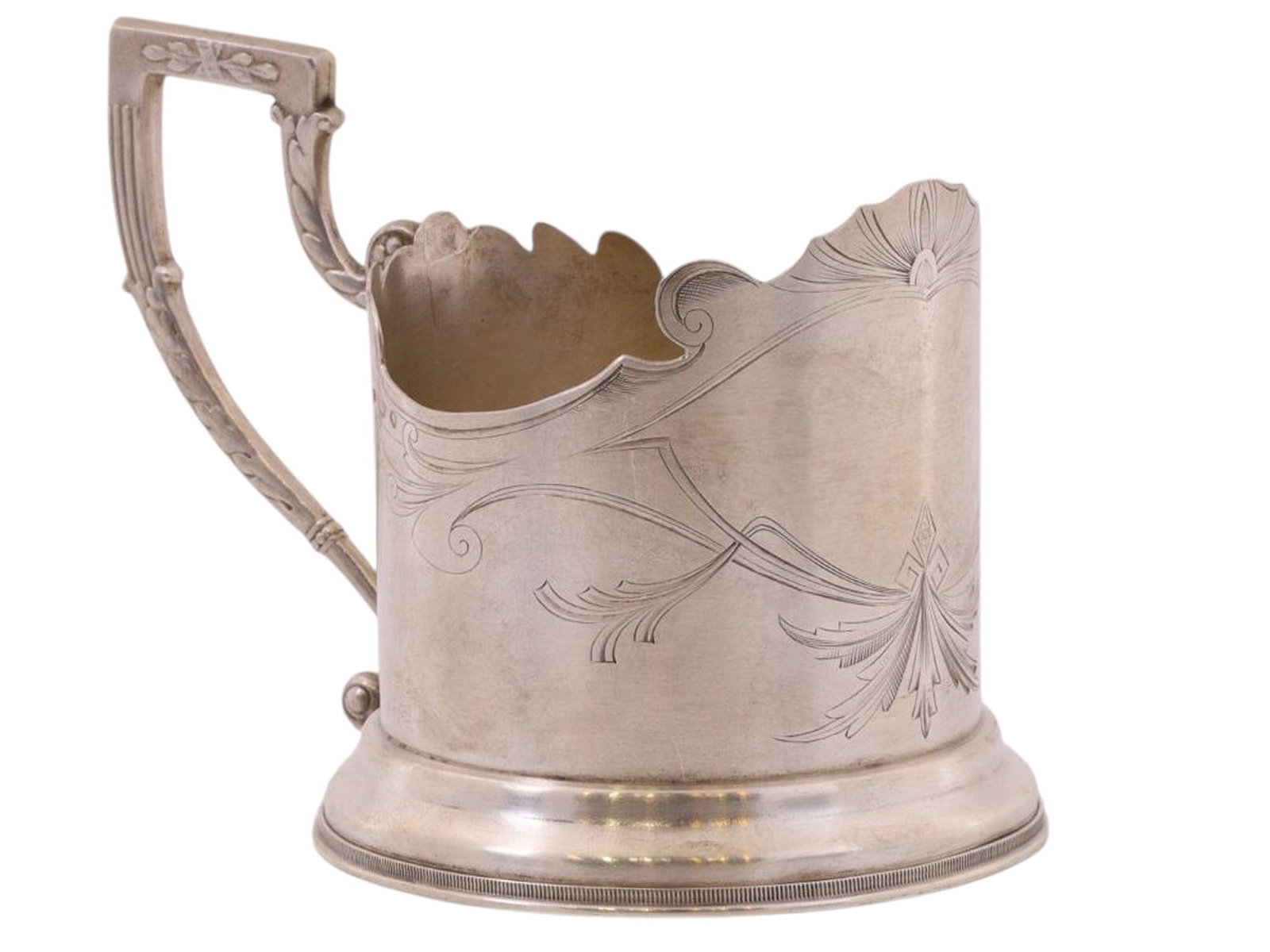 A RUSSIAN ART-NOUVEAU SILVER TEAGLASS HOLDER, PLATINUM FACTORY, EARLY 20TH CEN.: A cylindrical tea glass holder with a smooth body that widens slightly toward the bottom and a tall, profiled ring-shaped base. The top features a fancifully carved wavy rim. The body is engraved with