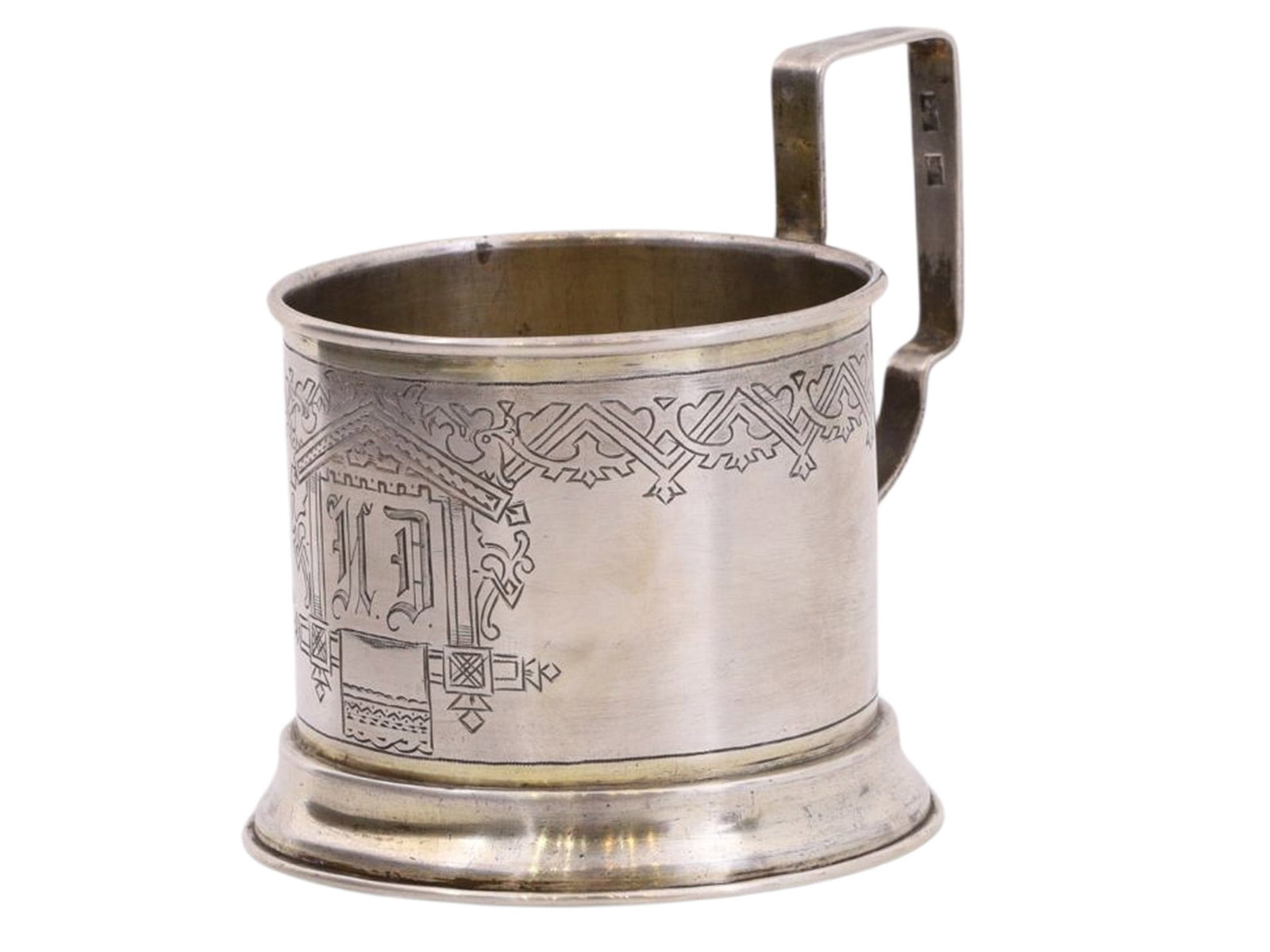 A RUSSIAN COMMEMORATIVE SILVER TEAGLASS HOLDER IN NEO-RUSSIAN STYLE, VASILY IVANOV WORKSHOP, 1886: A cylindrical tea glass holder with a rectangular handle, resting on a wide ring-shaped base, decorated with a geometric pattern depicting Russian towels and a central medallion in the form of a windo