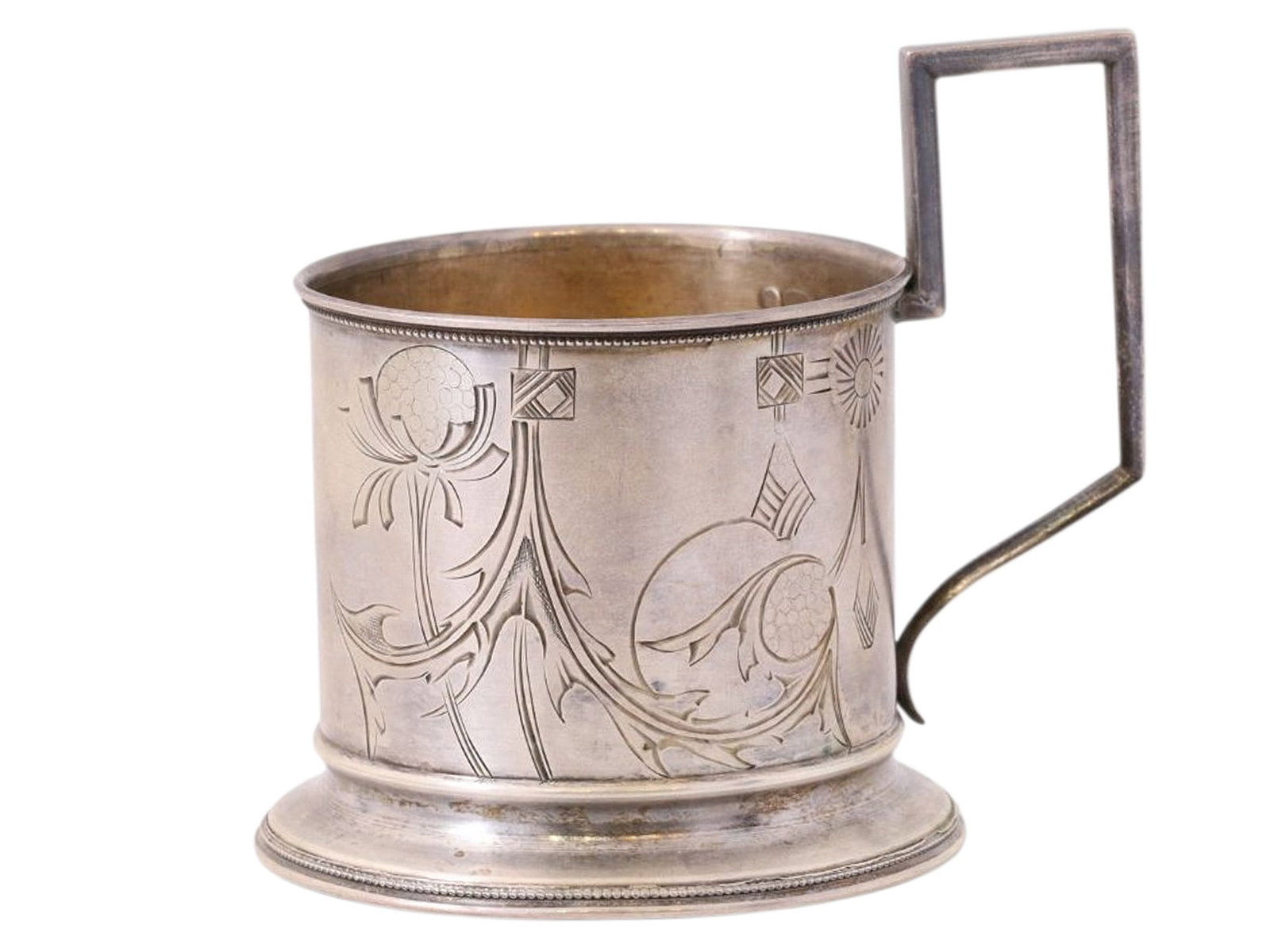 A RUSSIAN PARCEL-GILT SILVER TEA GLASS HOLDER IN ART NOUVEAU STYLE: A Russian parcel-gilt silver tea glass holder with its circumference engraved with floral and geometric patterns in the art nouveau style. The rime and the circular base both lined with a ring of silv