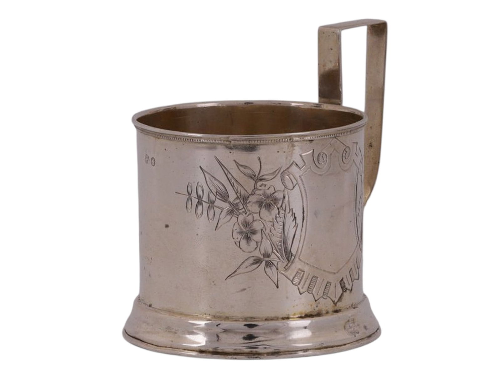 A RUSSIAN SILVER TEAGLASS HOLDER WITH ENGRAVED DECORATION: A Russian tea glass holder of typical form, with a ring of engraved floral decoration surrounding a blank area meant for a monogram.Hallmarks: Cyrillic 'RA' maker's mark, 84 silver proof, St George Mo