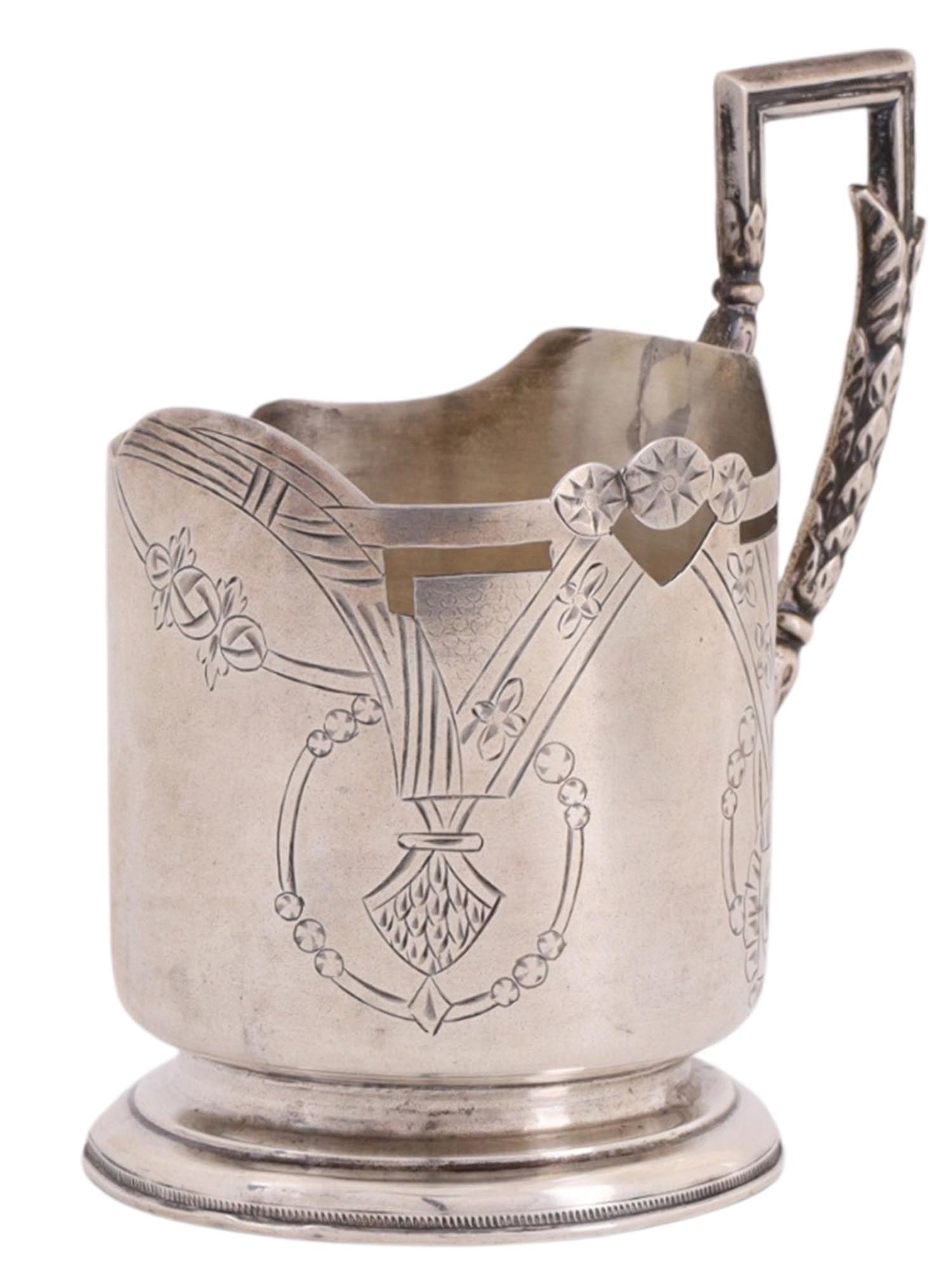 A RUSSIAN SILVER TEAGLASS HOLDER IN THE ART NOUVEAU STYLE, LATE 19TH TO EARLY 20TH CENTURY: Of cylindrical form on a ring foot, fitted with a relief twisted handle with vegetal ornament. The body with an asymmetrical pierced upper rim, decorated on one side with a vegetal and geometric compo