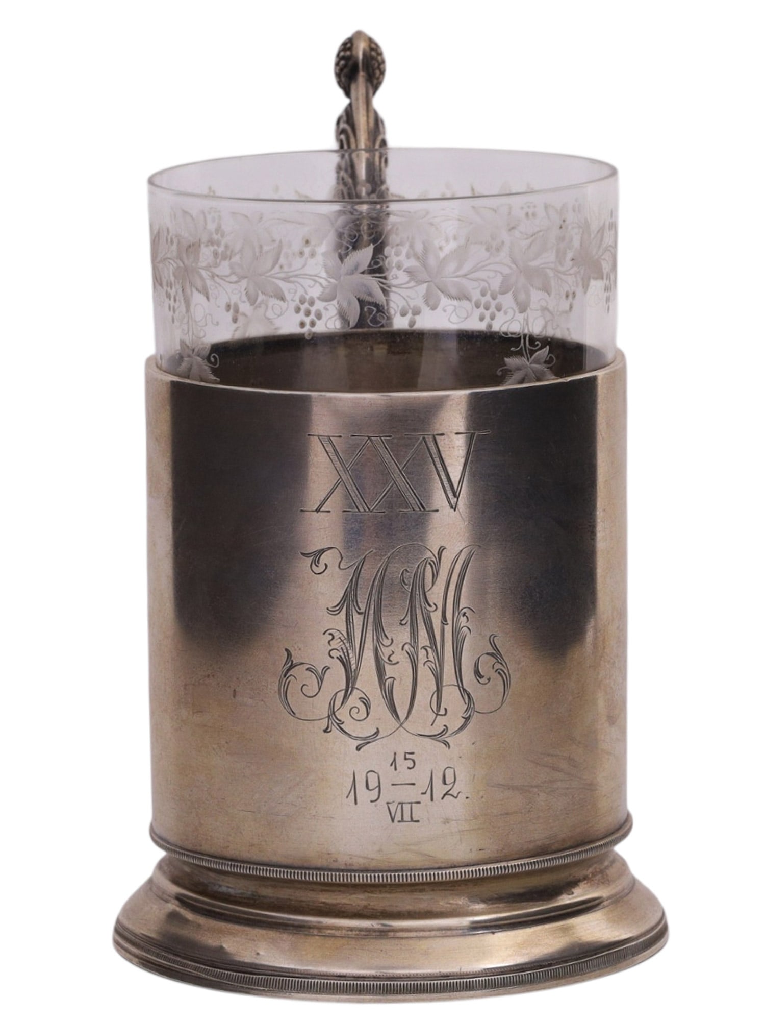 A RUSSIAN SILVER TEA GLASS HOLDER WITH A PRESENTATION INSCRIPTION: A Russian silver tea glass holder with engraved owner's initials "IM" in Cyrillic and date 15.07.1912. Made in Moscow by the workshop of Nikolay Zverev. Marked on the bottom with "NZ" in Cyrillic, 84 