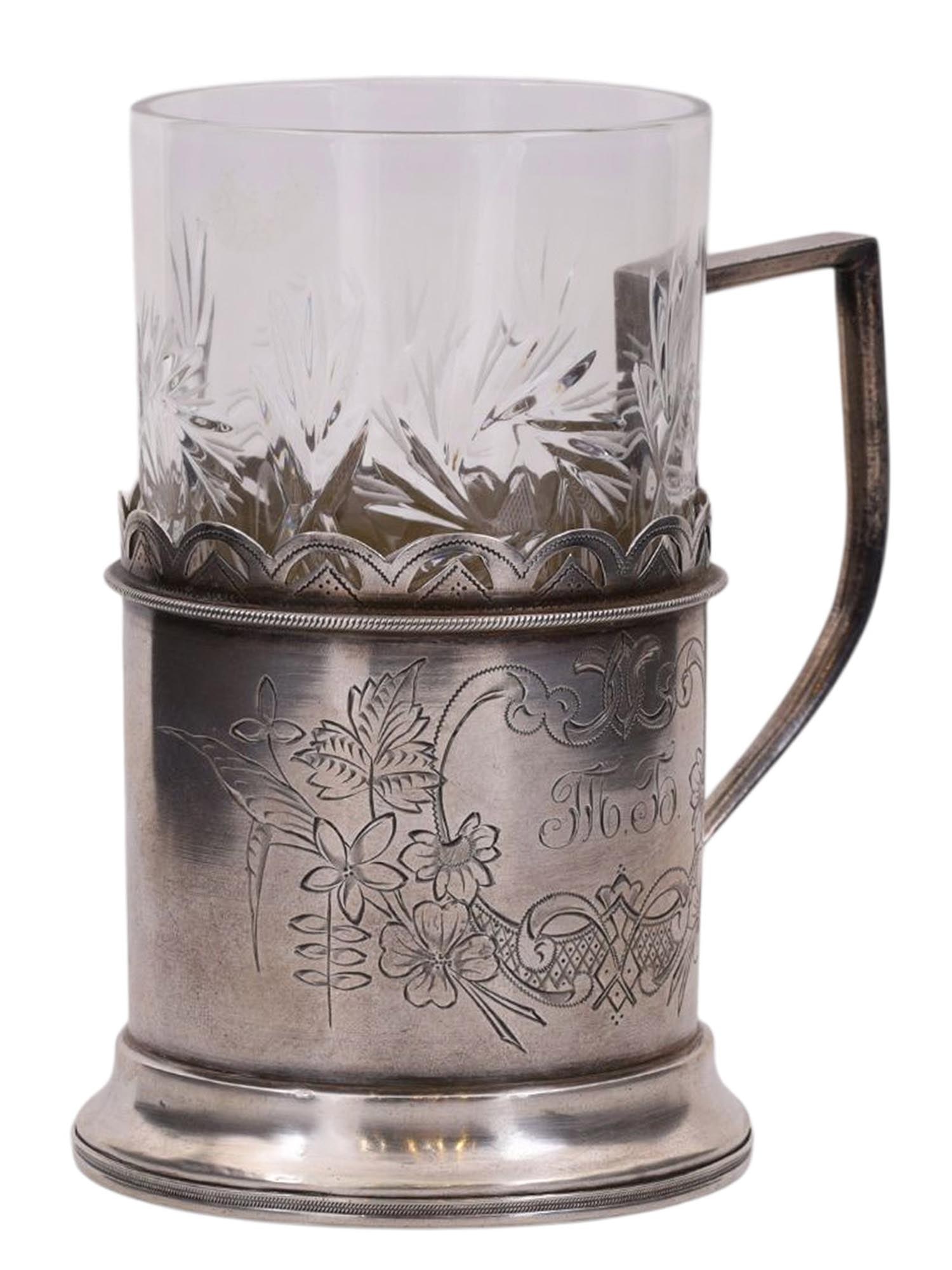A RUSSIAN SILVER TEAGLASS HOLDER WITH CUT CRYSTAL GLASS: A Russian silver tea glass holder with delicate floral engraving surrounding a monogram reading 'MB'. Kept within the holder is a cut-crystal glass.Hallmarks: Soviet star with 875 silver proof, 84 sil