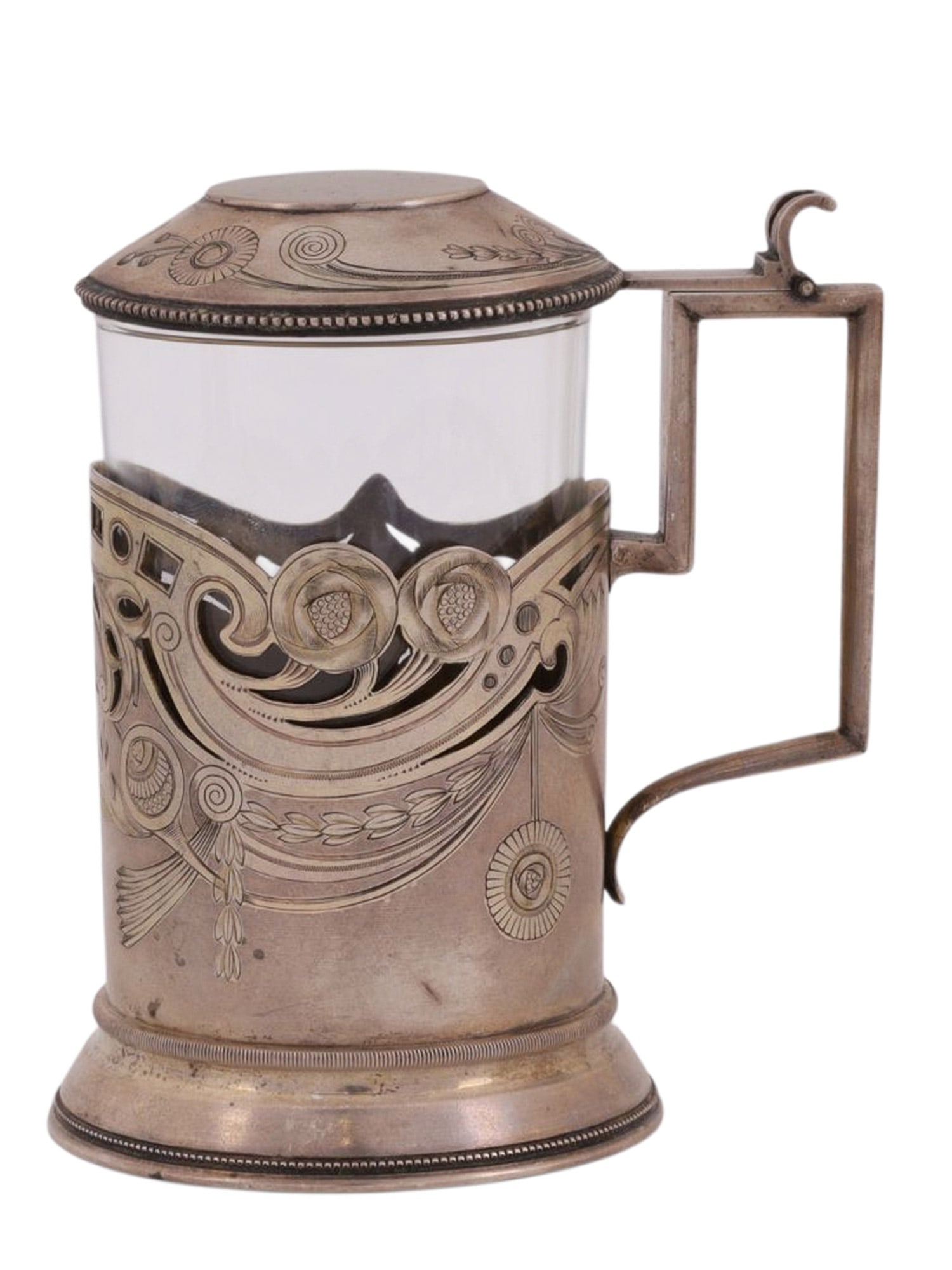 A RUSSIAN LIDDED SILVER TEAGLASS HOLDER WITH GLASS: A Russian Silver Podstakannik in Art-Nouveau style, complete with its glass and a shallow, coned lid which can be operated from the handle. The cup with intricate and flowing engraved and openwork flo