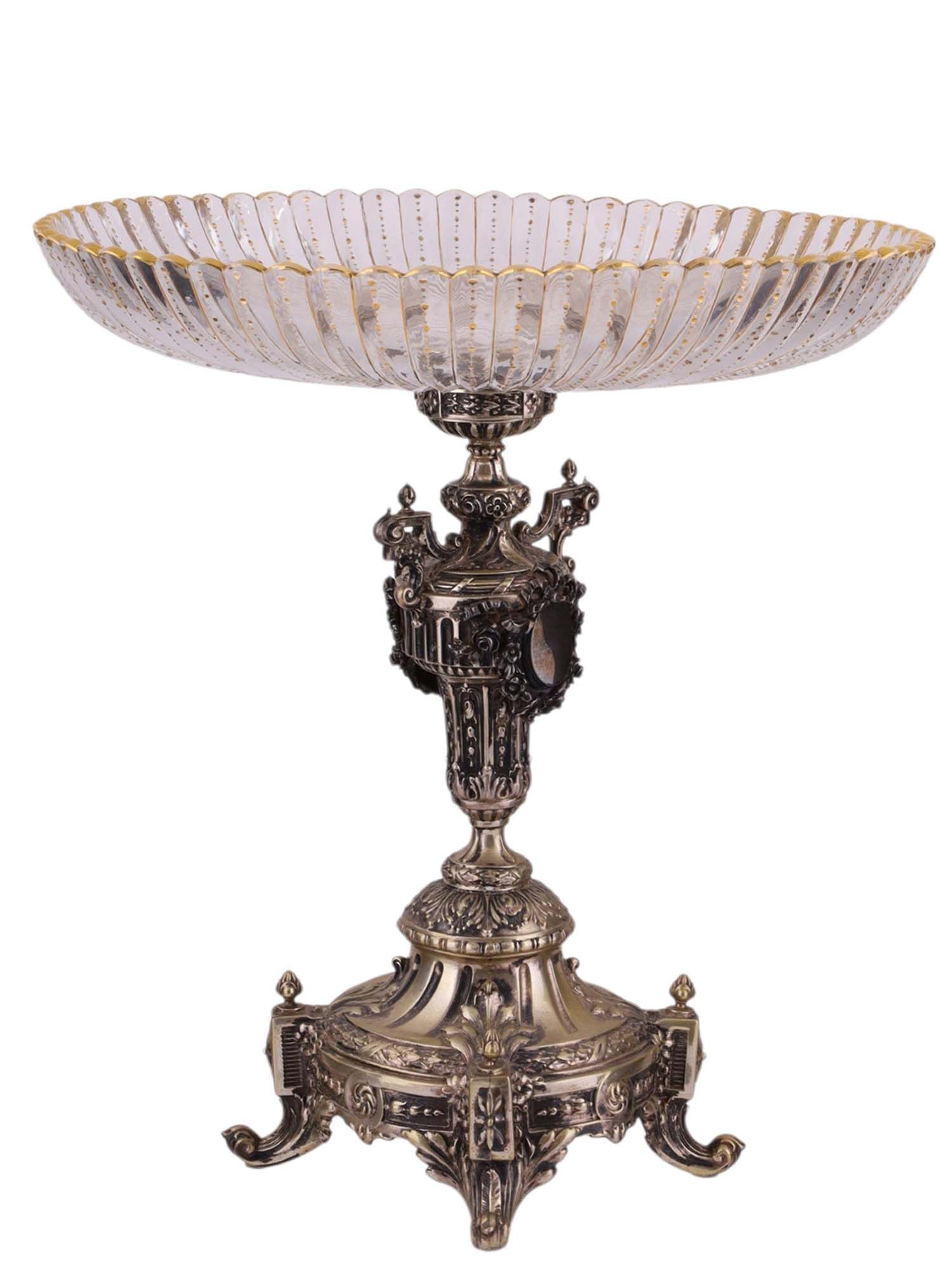 A CONTINENTAL SILVERED AND CUT CRYSTAL PEDESTAL COMPOTE BOWL, LATE 19TH CENTURY: The compote formed as a wide, shallow cut crystal bowl with fluted sides and gilt highlights, raised on an elaborately cast and chased silvered pedestal, the stem decorated with classical and foliate 