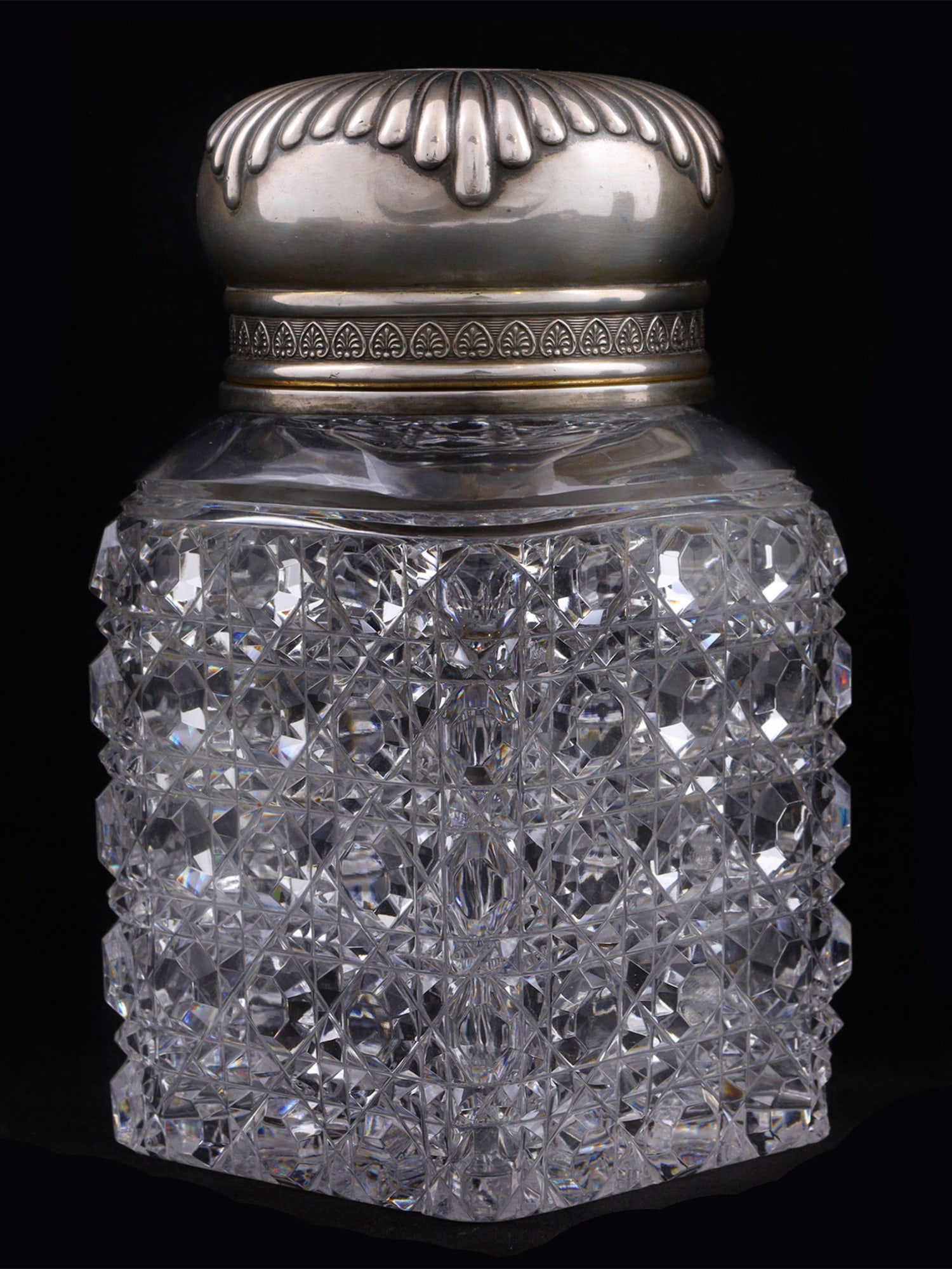 A RUSSIAN CUT-GLASS AND PARCEL-GILT SILVER TEA CADDY BY MOROZOV, 19 C.: The body is cut in an elaborate, geometric pattern (Russian cut). The silver lid is decorated with a design forming a breast order star-like shape. The central cartouche is monogrammed with intertwine
