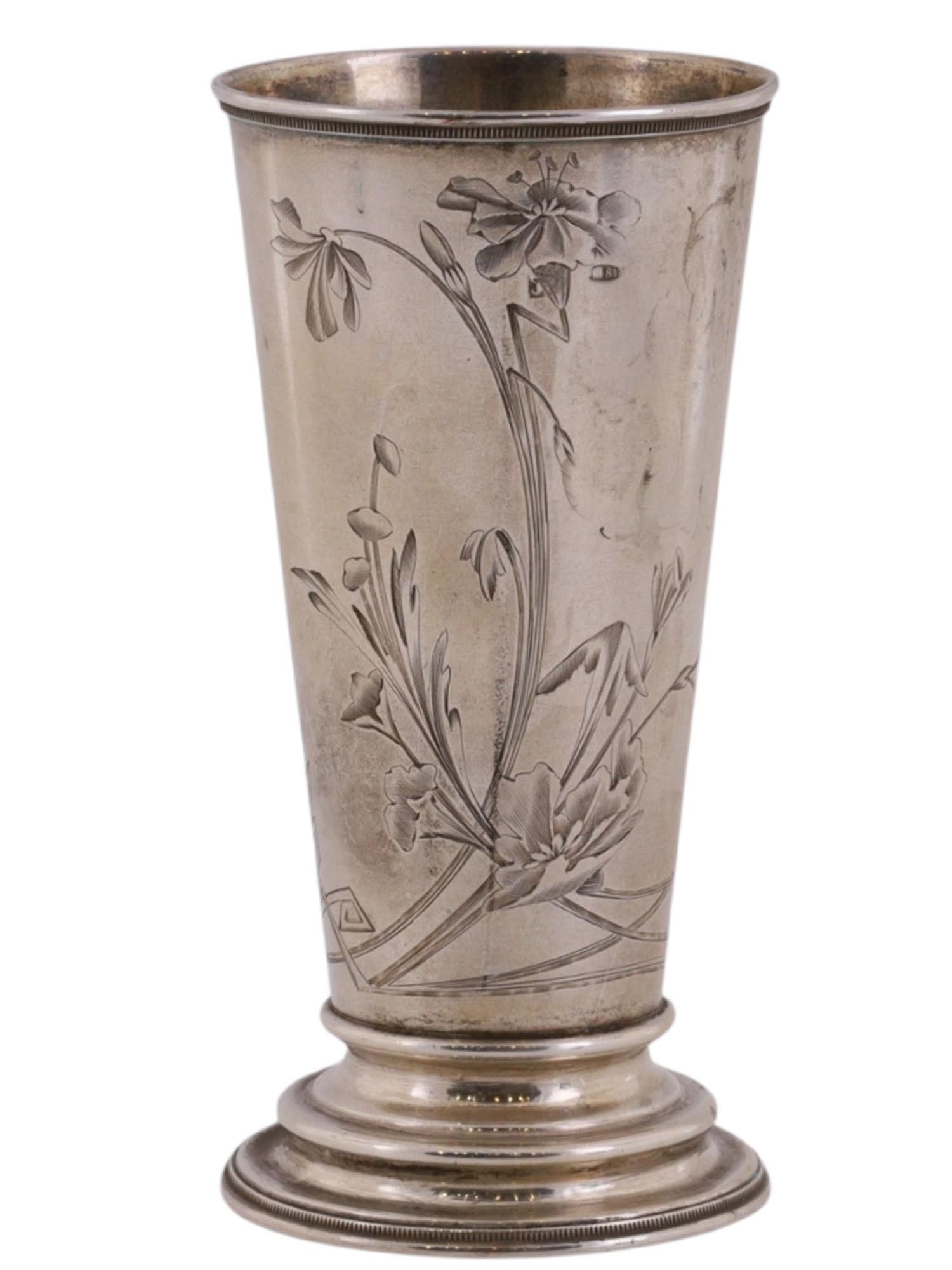 A RUSSIAN ENGRAVED SILVER SHOT GLASS WITH FLORAL DECORATION: Of conical form on a low ring foot, the body engraved with an asymmetrical floral composition in the Art Nouveau taste. The flowing ornament reflects the transition toward organic decorative forms cha