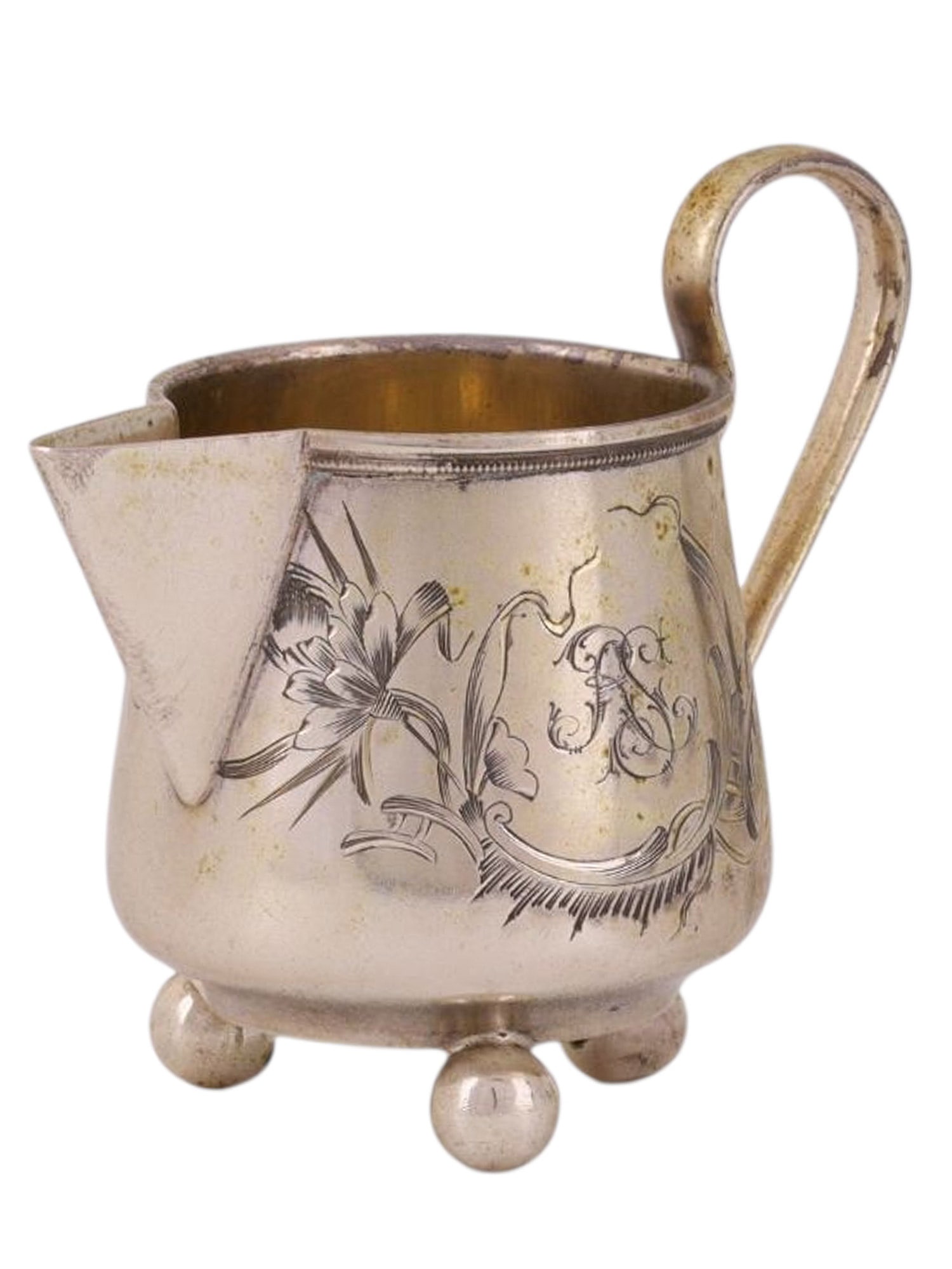 A RUSSIAN ART-NOUVEAU SILVER CREAMER, VASILY SEMENOV WORKSHOP, 19TH CEN.: A creamer jug standing on three spherical legs, with a smooth, curved handle and a triangular spout; one side is decorated with an asymmetrical engraved floral pattern forming a medallion. A monogram 