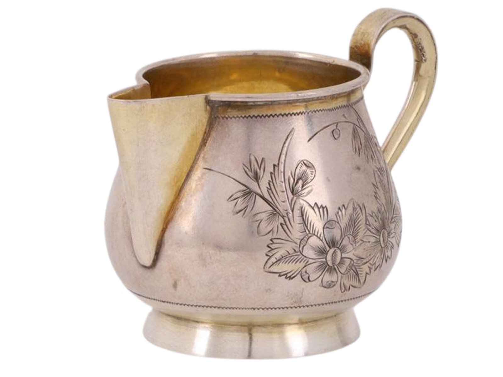 A RUSSIAN PARCEL-GILT SILVER CREAMER WITH FLORAL DECORATION, PRIVATE WORKSHOP, MOSCOW, LATE 19TH: Of pear-shaped form with an S shaped handle, the body engraved on one side with a floral composition forming a decorative medallion. The interior is gilt, providing a warm contrast to the polished ext