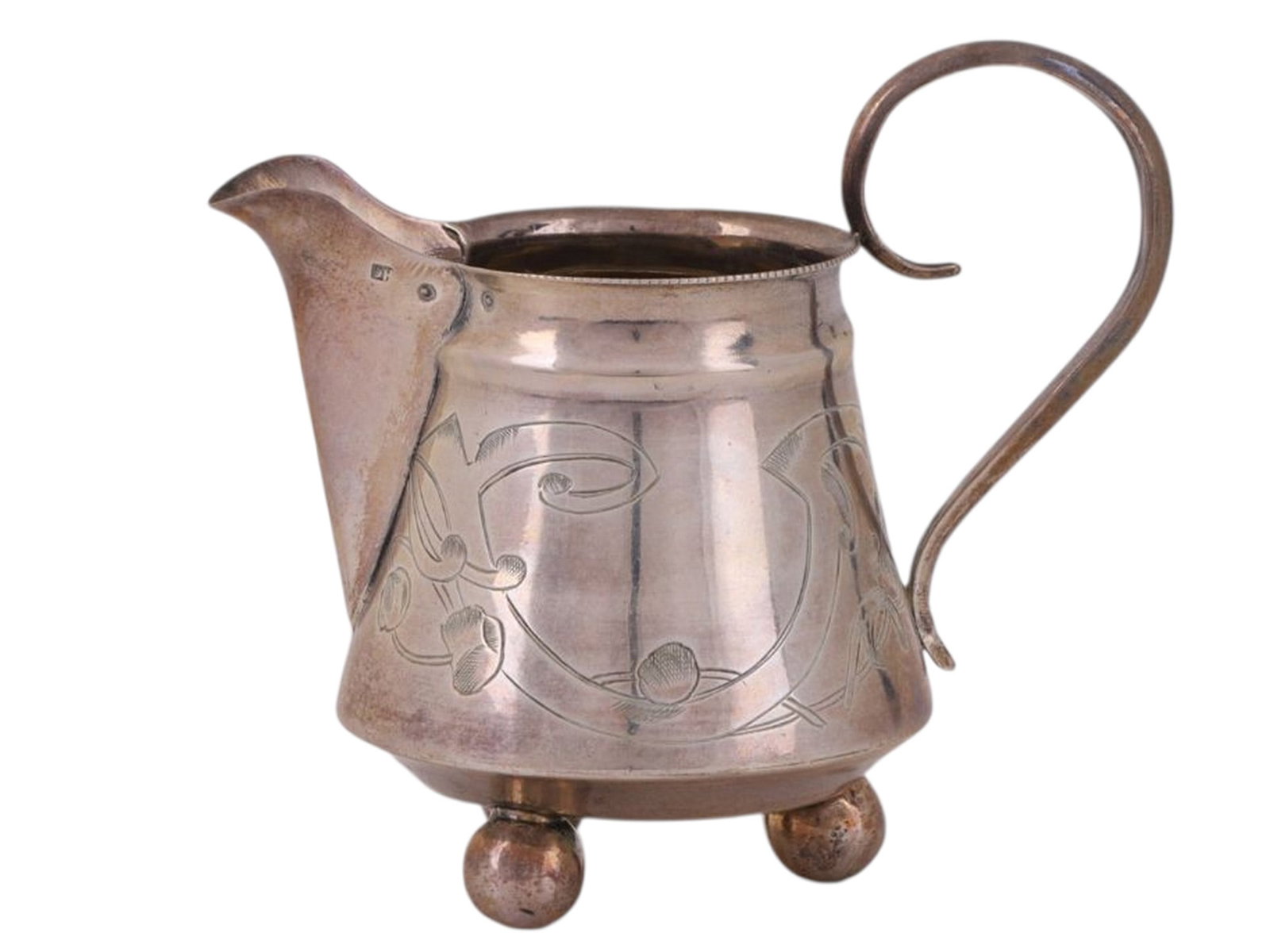A RUSSIAN SILVER CREAMER IN THE ART NOUVEAU STYLE, WORKSHOP OF NIKOLAI STRULEV, MOSCOW, RUSSIA,: Of tapering conical form, widening toward the base, raised on three ball feet, with an S-shaped handle. The body is engraved with a floral and geometric ornament characteristic of the Art Nouveau styl