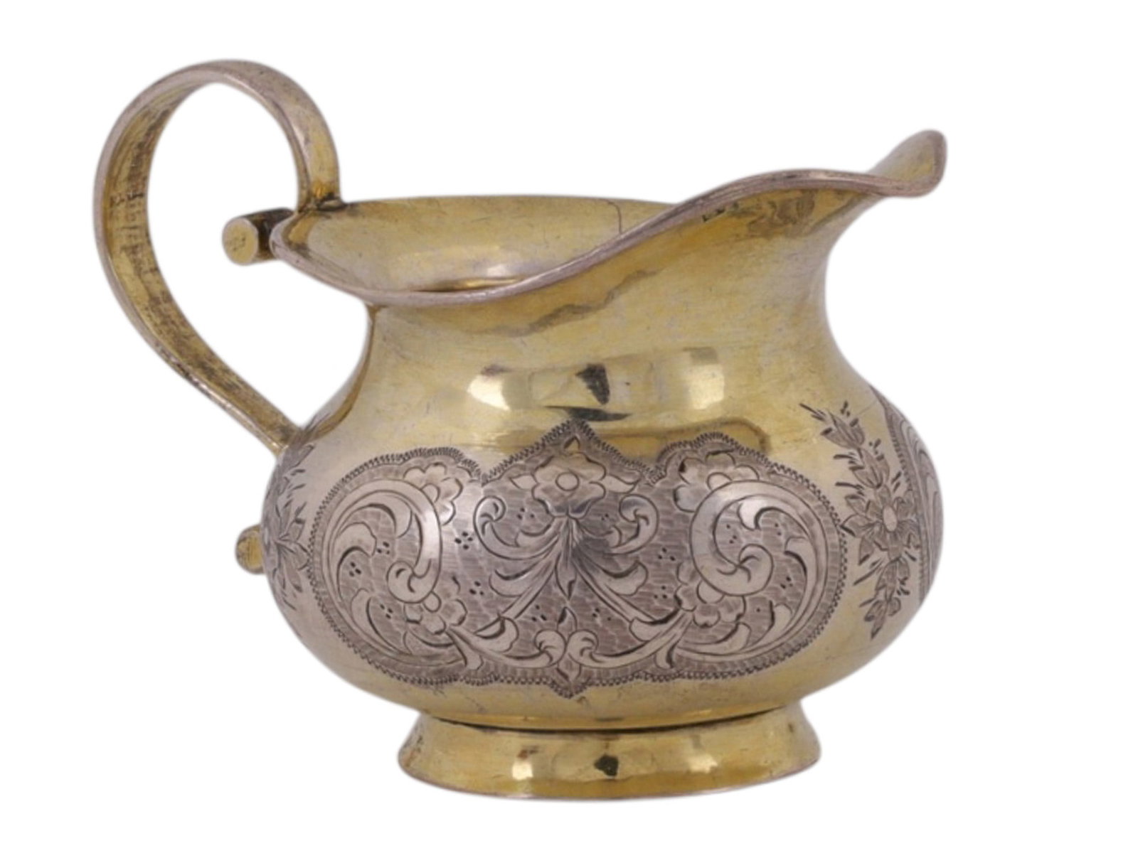 A RUSSIAN PARCEL-GILT AND NIELLO SILVER CREAMER, PRIVATE WORKSHOP, MOSCOW, LATE 19TH CENTURY: Of low, bulbous form on a ring foot, the body decorated on both sides with symmetrical engraved floral compositions enhanced with niello. The interior and exterior are gilt, creating a rich contrast w