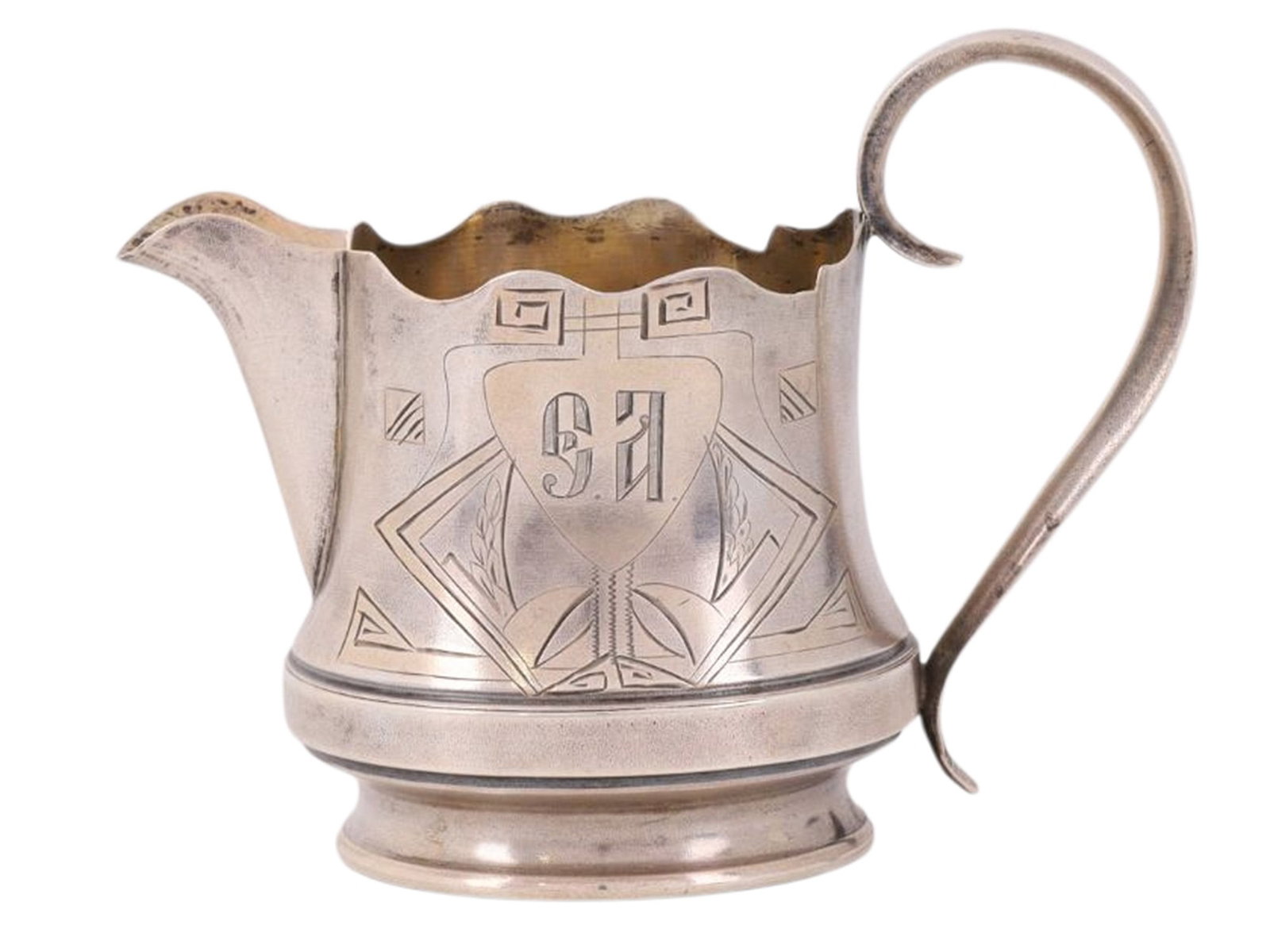 A RUSSIAN PARCEL-GILT SILVER CREAMER IN NEO-RUSSIAN STYLE: A Russian parcel-gilt silver creamer engraved and decorated in the Neo-Russian style, with a curved handle affixed to its back, and a monogram on its side.Hallmarks: 84 silver proof with kokoshnik, Cy