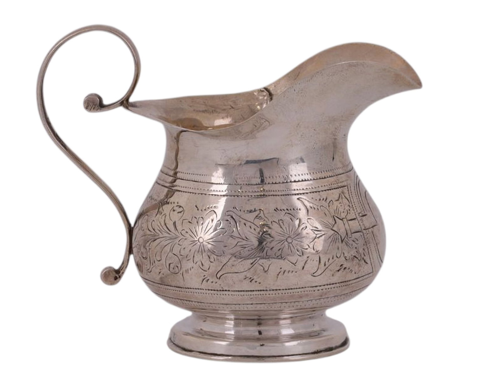 A RUSSIAN SILVER CREAMER WITH ENGRAVED DECORATION, 1887: A Russian silver creamer jug with its belly engraved with floral motifs, a curved handle affixed to the back.Hallmarks: St George Moscow mark, 'A.P' assayer's mark over 1887 date mark, 84 silver proof