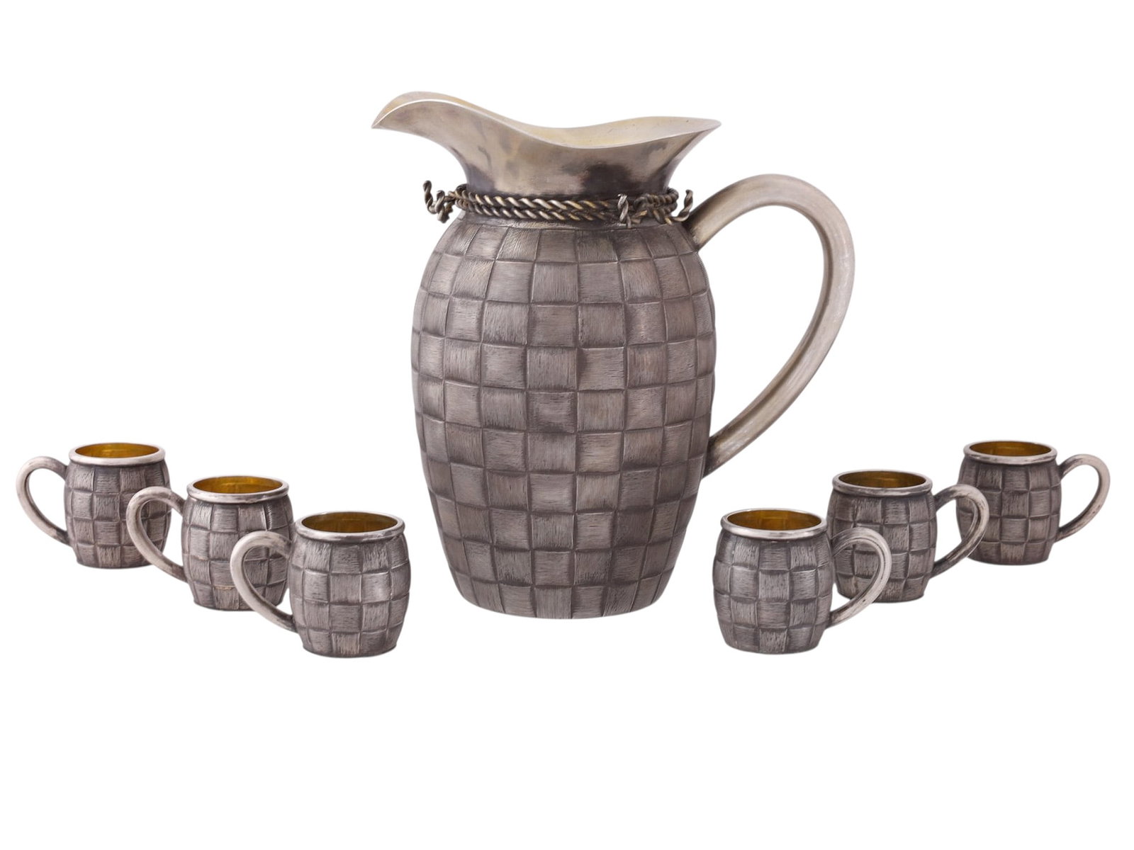 A RUSSIAN PARCEL-GILT SILVER JUG WITH SIX CUPS, TROMPE L’OEIL: A parcel-gilt silver trompe l’oeil drinking set comprising six cups and an jug.Hallmarks: Khlebnikov maker's mark, Imperal Warrant Eagle, 'A.A' assayer's mark over 1889 date mark, 84 silver proo