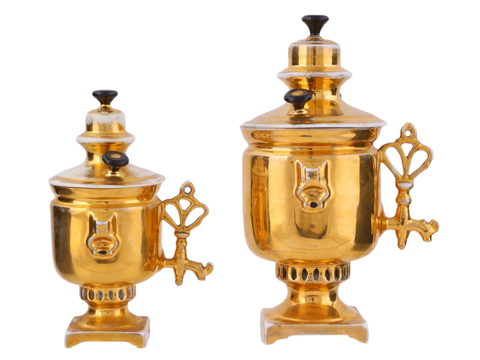 TWO RUSSIAN PORCELAIN MINIATURE SAMOVARS BY THE KUZNETSOV FACTORY, EARLY 20TH CENTURY: Each modeled in traditional samovar form with domed cover and knop finial, fitted with a spigot and stylized loop handles, raised on a square base, the surfaces richly gilt. The undersides with blue u