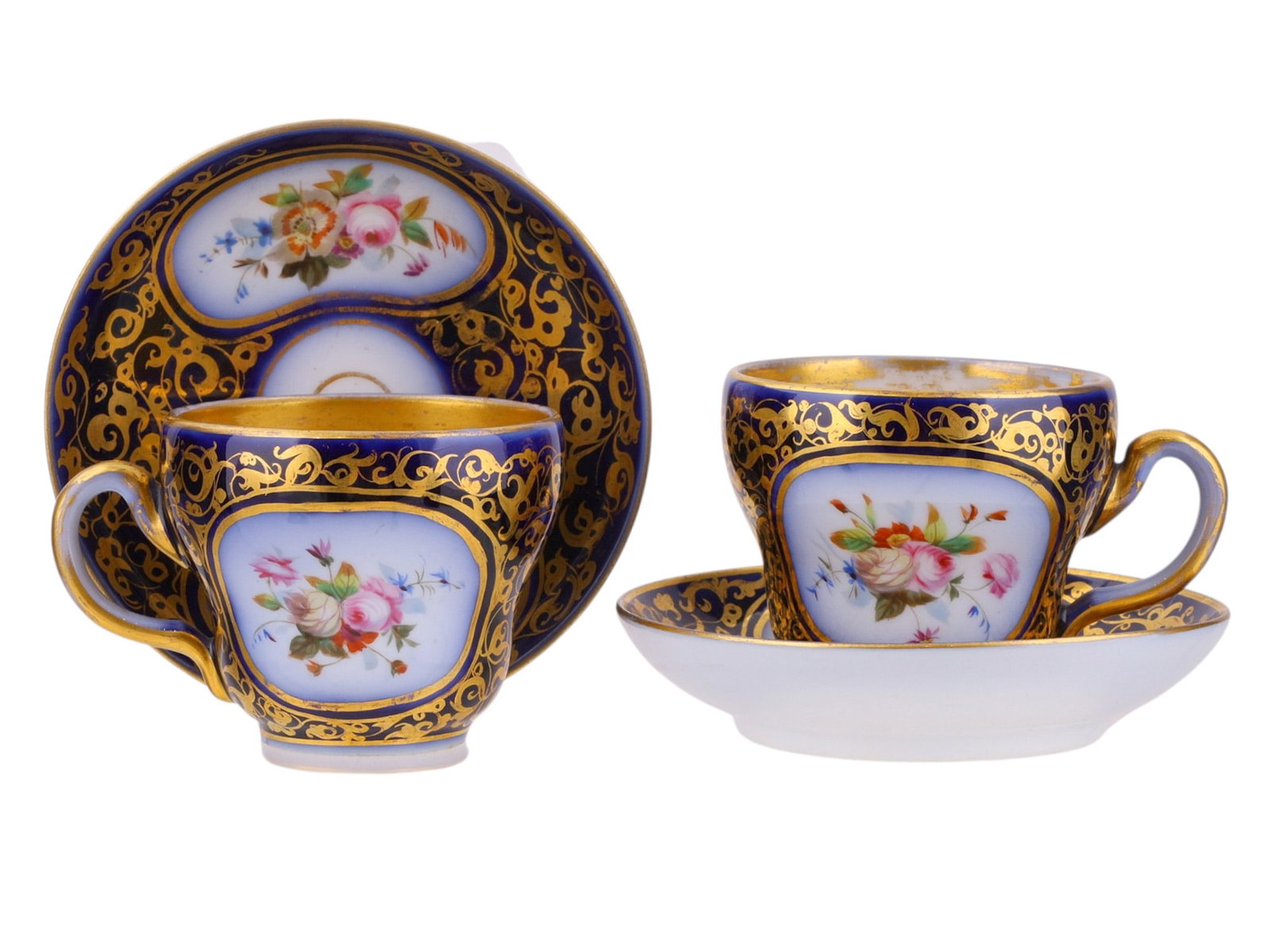 A LOT OF TWO CUPS AND SAUCERS, POSSIBLY RUSSIAN, 19TH CEN.: Each finely potted porcelain cup of tapering cylindrical form with a loop handle, richly decorated on a deep cobalt-blue ground with elaborate gilt scrolling arabesques. The cartouches on the cups and