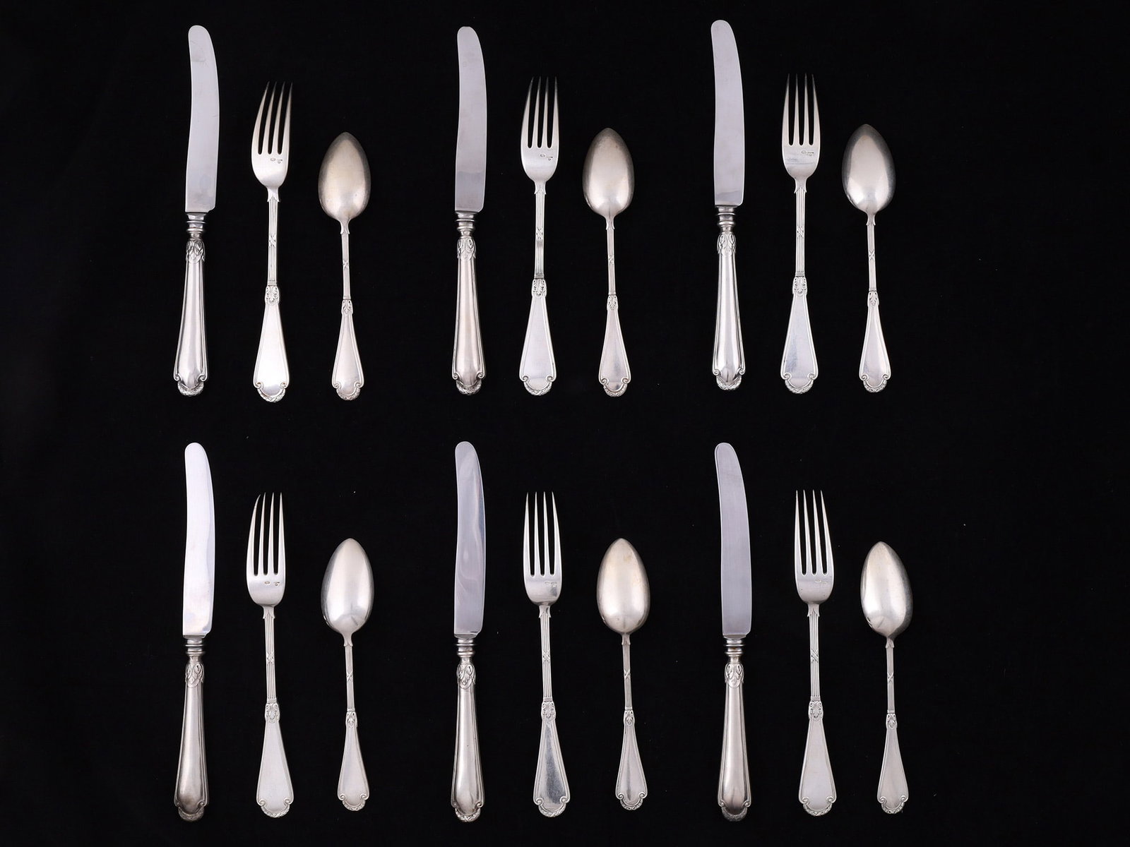 A LOT OF EIGHTEEN FABERGÉ RUSSIAN SILVER FLATWARE PIECES, MOSCOW, CIRCA 1900: Comprising six table knives with silver handles and steel blades, six tablespoons, and six dinner forks. Each piece was executed in the refined late-Imperial Russian Rococo-revival taste characteristi