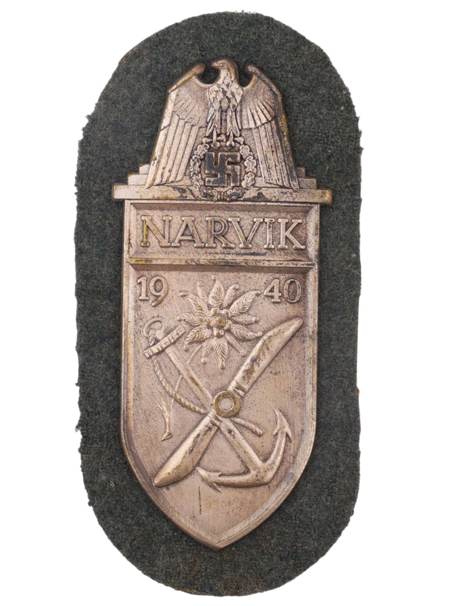 A GERMAN NARVIK CAMPAIGN SHIELD, 1940, THIRD REICH PERIOD: Constructed of die-struck silvered metal in the form of a heraldic shield surmounted by a national eagle clutching a swastika wreath. The shield bears the inscription "NARVIK" above the date "1940" an