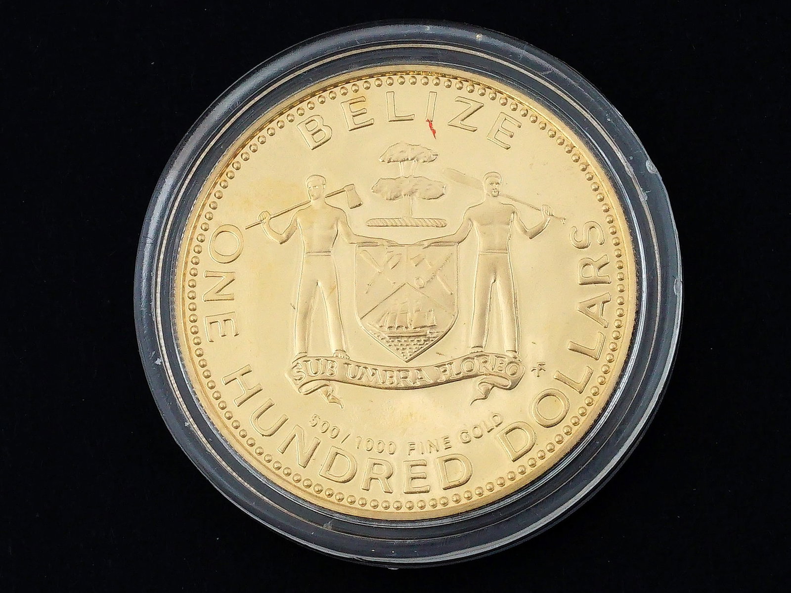 BELIZE 100 DOLLARS KM# 59 1979FM (U) COIN: A Belize gold 100 dollar coin with the National Arms on the front with the denomination, and the Star of Bethlehem on the back, with the date.Belize, 20th century.Weight: 6.47 grams Dimensions: Approx
