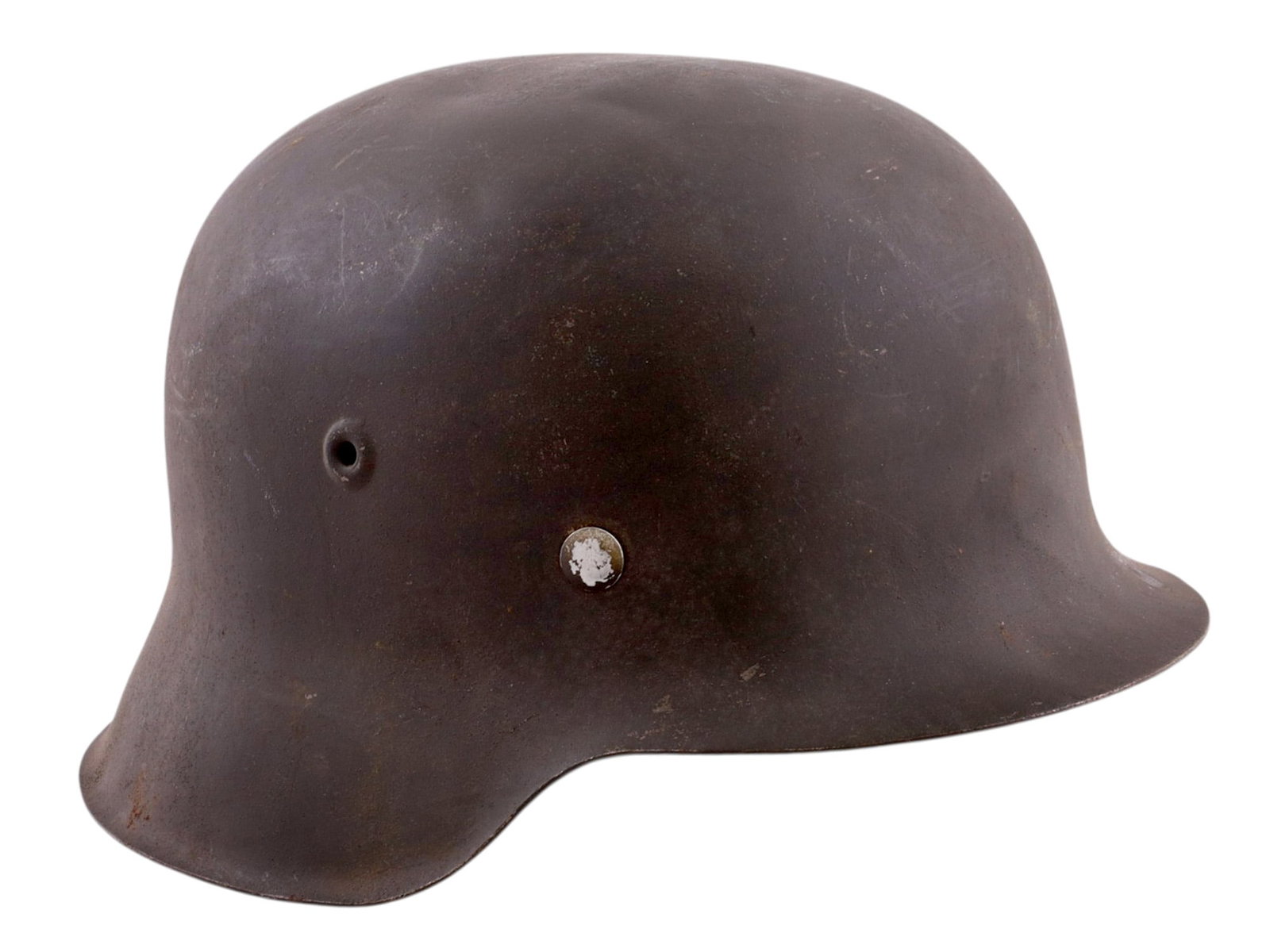 A GERMAN M42 STEEL COMBAT HELMET, WORLD WAR II: Pressed steel combat helmet of the M42 pattern, featuring the characteristic simplified rolled-edge construction introduced in 1942 for wartime production efficiency. Retaining its original field-gray
