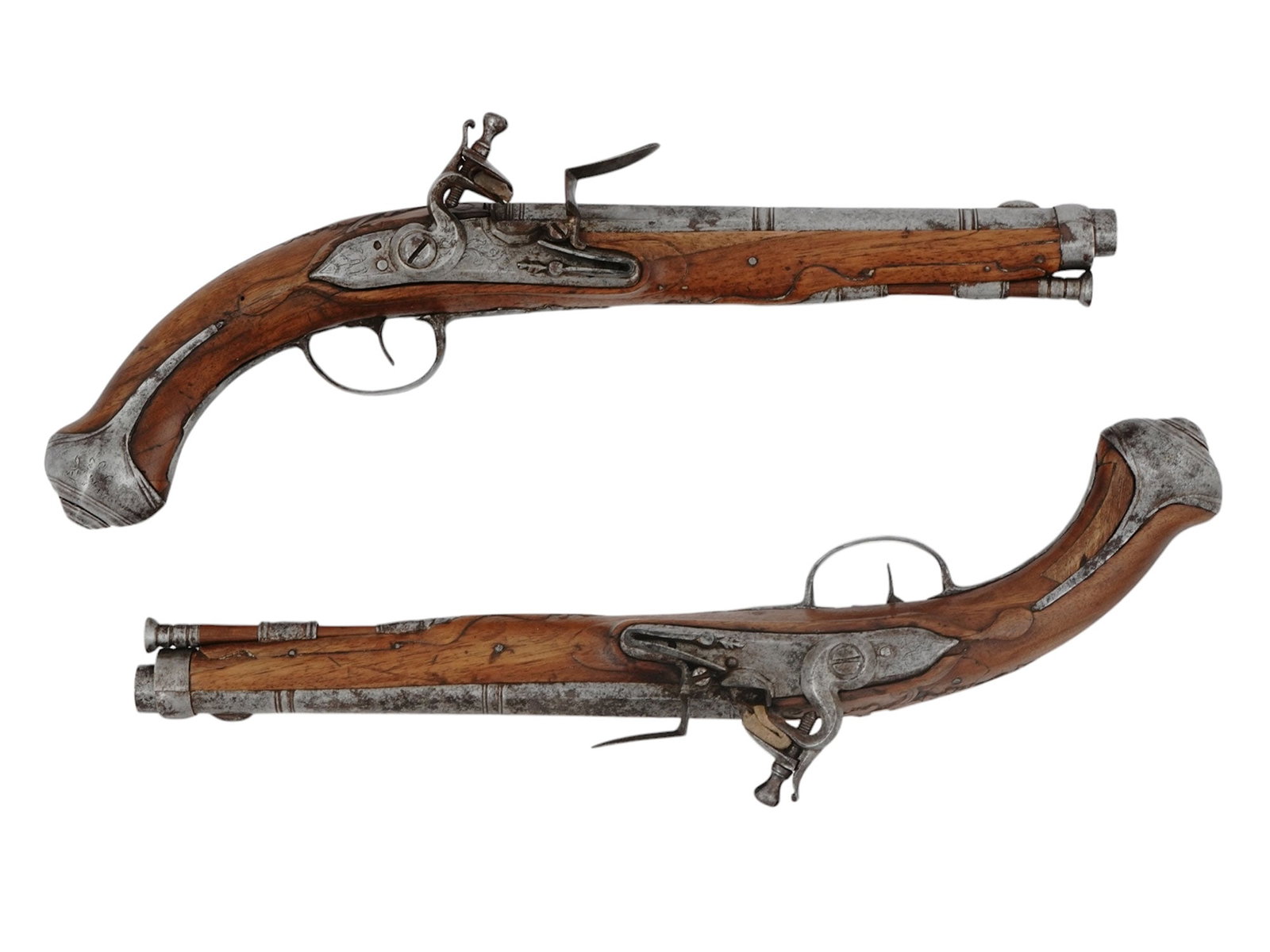 A MATCHED PAIR OF EUROPEAN FLINTLOCK PISTOLS, 18TH CENTURY: A matching pair of European smoothbore flintlock pistols, both with nicely carved wood stocks with scrollwork decoration to the backstrap. The barrels are octagonal for the first half, then transition