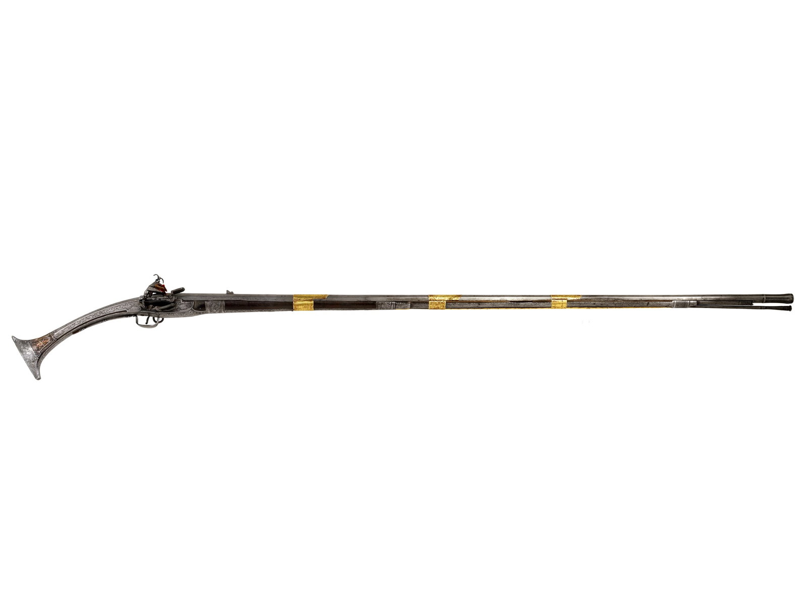A BALKAN (PROBABLY ALBANIAN) 18-BORE MIQUELET-LOCK RIFLE (ARNAUTKA), EARLY 19TH CENTURY: An Arnautka (Tançica) with a long octagonal barrel stamped with a proof mark near the breech, affixed with a raised rear sight, and the muzzle flared, fluted, and chased. The stock is of wood ove