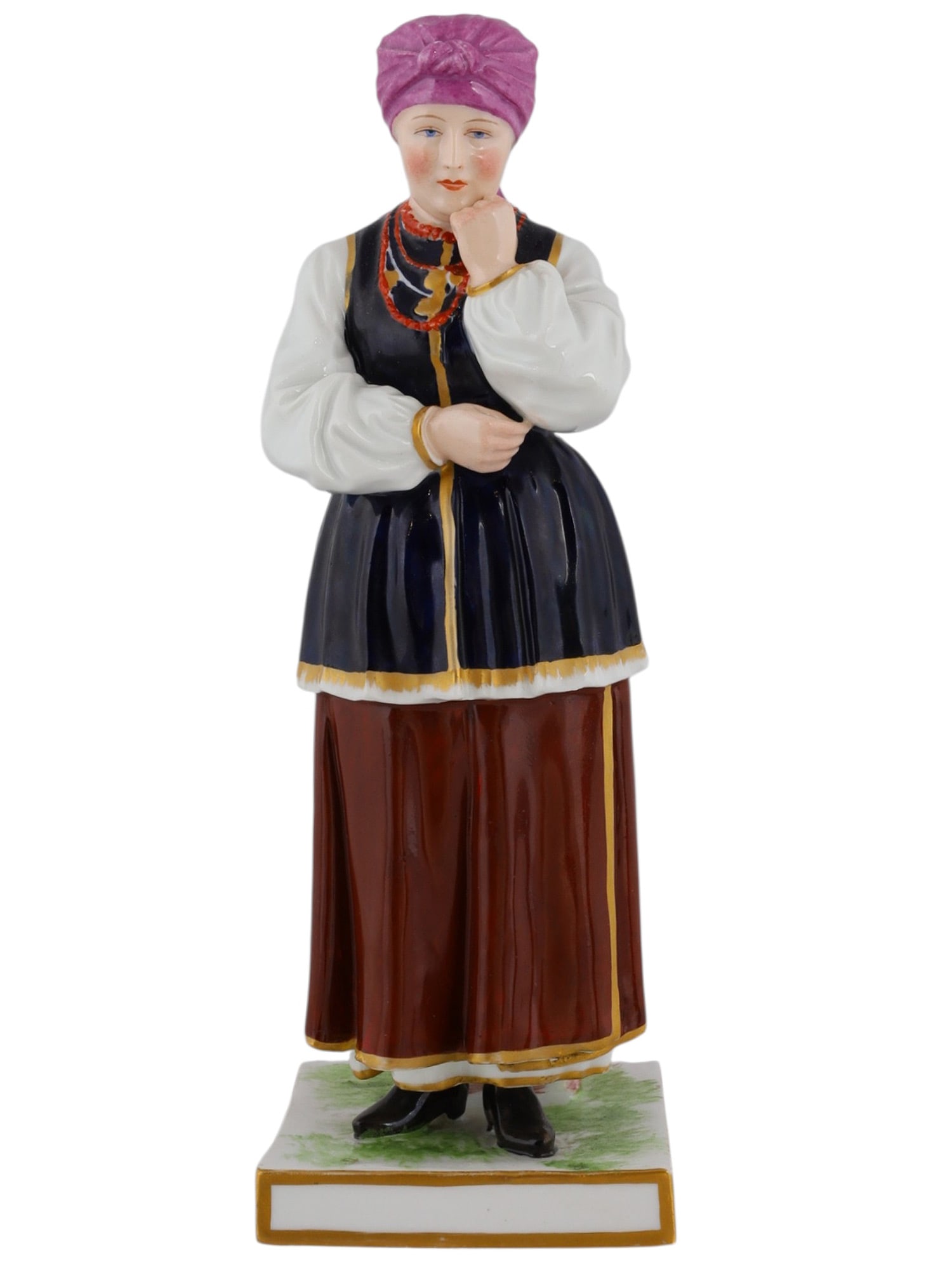 A RUSSIAN POPOV PORCELAIN FIGURE OF A UKRAINIAN WOMAN: A Russian porcelain figure of a Ukrainian woman in traditional dress, produced by the Popov Porcelain Manufactory. The underside is marked with the Popov symbol in blue ink, as well as a scratched Rom