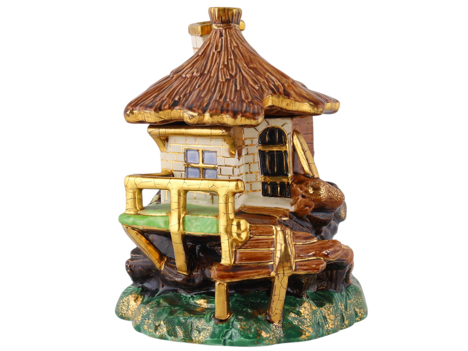 A RUSSIAN KUZNETSOV POLYCHROME AND GILT FAIENCE HOUSE-FORM COVERED TOBACCO BOX: Late 19th/early 20th century.Modelled as a rustic cottage with a removable thatched roof forming the cover, the walls detailed with masonry, timber boarding, windows and a chimney. The front with a ra