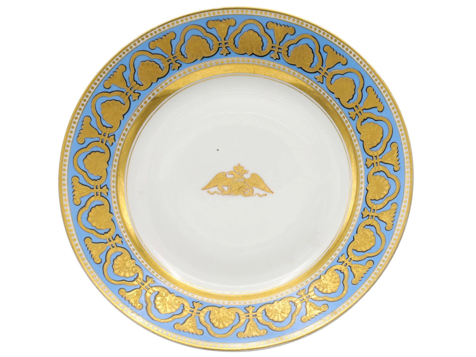 AN IMPERIAL RUSSIAN PORCELAIN MFG ROPSHA SERVICE DINNER PLATE, AIII: Imperial Porcelain Factory, 1881-1894.The center is decorated with an Imperial double-headed Eagle holding a torch and laurel wreath, the border is painted with gilt ornament over blue ground, and a g