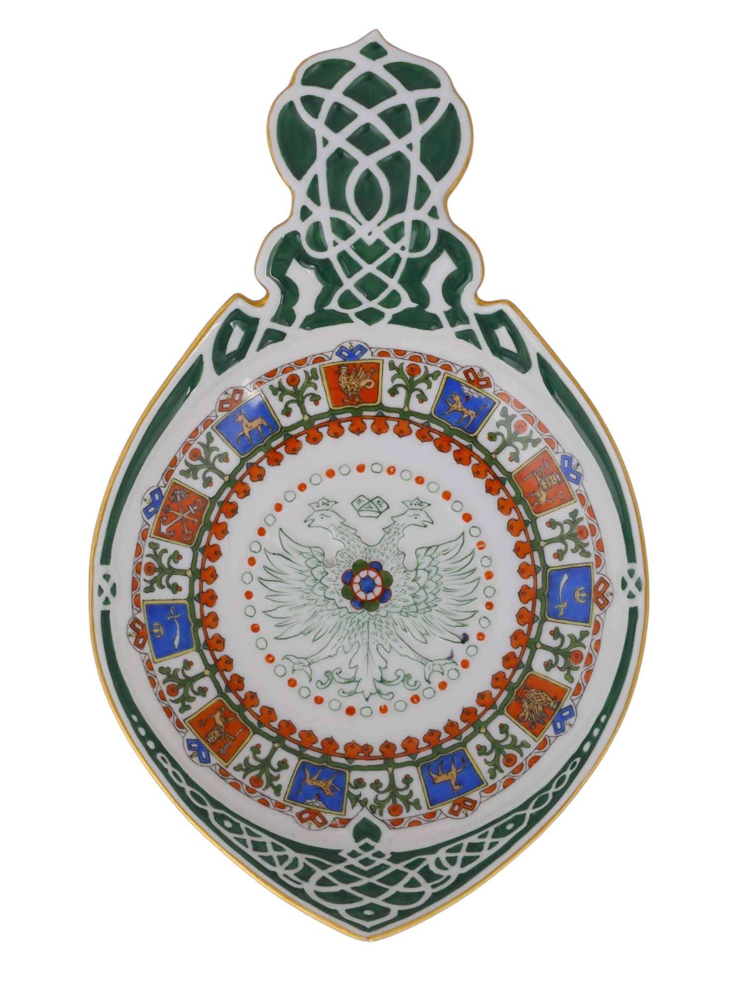 A RUSSIAN KORNILOV BROTHERS PORCELAIN PAN-SLAVIC KOVSH ST. PETERSBURG, CIRCA 1900: Of traditional kovsh form, raised on a circular foot and terminating in a large, flat, pierced handle decorated with green interlaced strapwork. The interior is centered with the Imperial Russian doub
