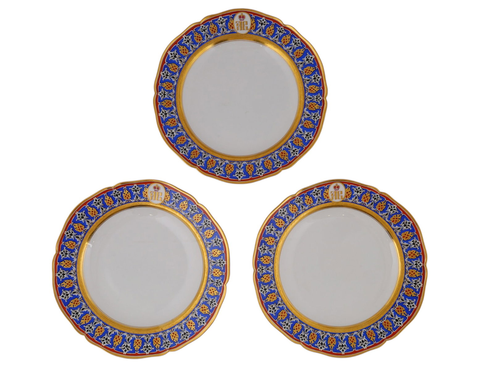 A LOT OF THREE BERLIN (KPM) PORCELAIN PLATES FROM A SERVICE OF THE GRAND DUKE ANDREI VLADIMIROVICH: Each circular plate with a scalloped rim, the border painted with a cobalt-blue ground enclosed by iron-red and gilt bands and decorated with alternating gilt strapwork motifs and black-and-white foli