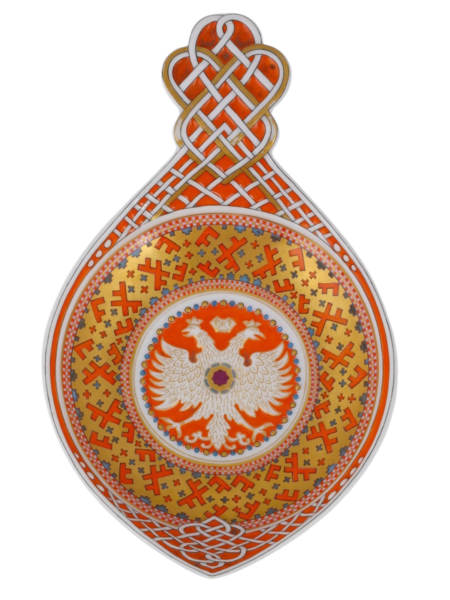 A RUSSIAN KORNILOV BROTHERS PORCELAIN PAN-SLAVIC KOVSH, ST. PETERSBURG, DATED 1897: Of traditional elongated oval form with a pointed prow and tall, flat pierced handle, the center decorated with a white and gilt Imperial double-headed eagle on an orange-red ground. The eagle is encl