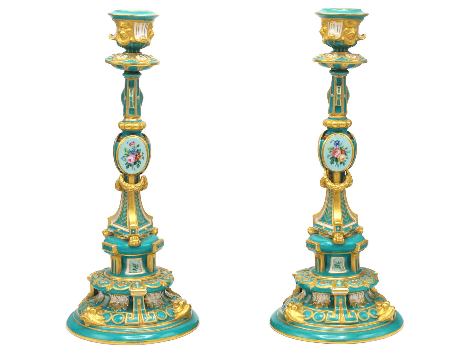 A PAIR OF RUSSIAN PORCELAIN CANDLESTICKS, IMPERIAL PORCELAIN FACTORY, ST. PETERSBURG, PERIOD OF: Each modeled in an elaborate historicist style and decorated with a turquoise ground enriched with extensive gilding. The spreading stepped circular bases are molded with scrolls, palmettes, and acant