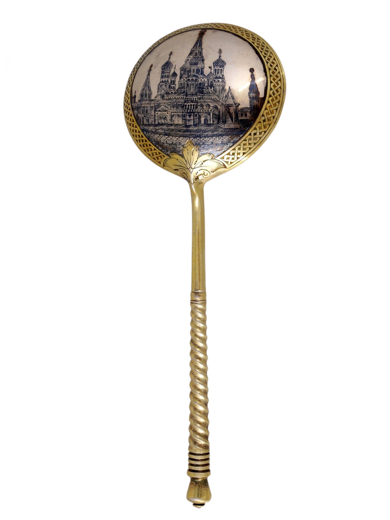 A RUSSIAN SILVER-GILT AND NIELLO SPOON, MOSCOW, 1895: The circular bowl is decorated in niello with a detailed view of the Cathedral of Saint Basil the Blessed, Moscow, enclosed by an engraved border and issuing from stylized foliage. The tapering handle