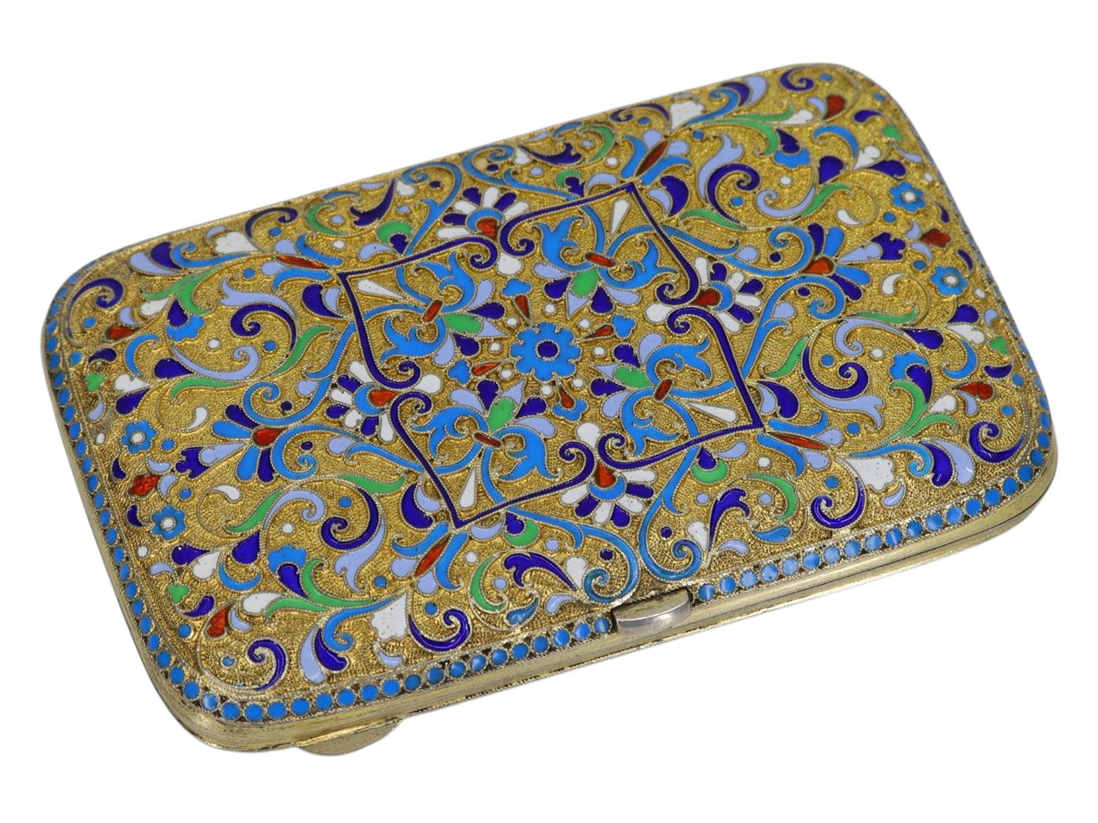A RUSSIAN GILT-SILVER CLOISONN? ENAMEL CIGARETTE CASE, 1899-1908: Moscow, 1899–1908.Of rectangular form with rounded corners and a hinged lid, the exterior is richly decorated in polychrome shaded cloisonné enamel over a stippled gilt ground. The design f