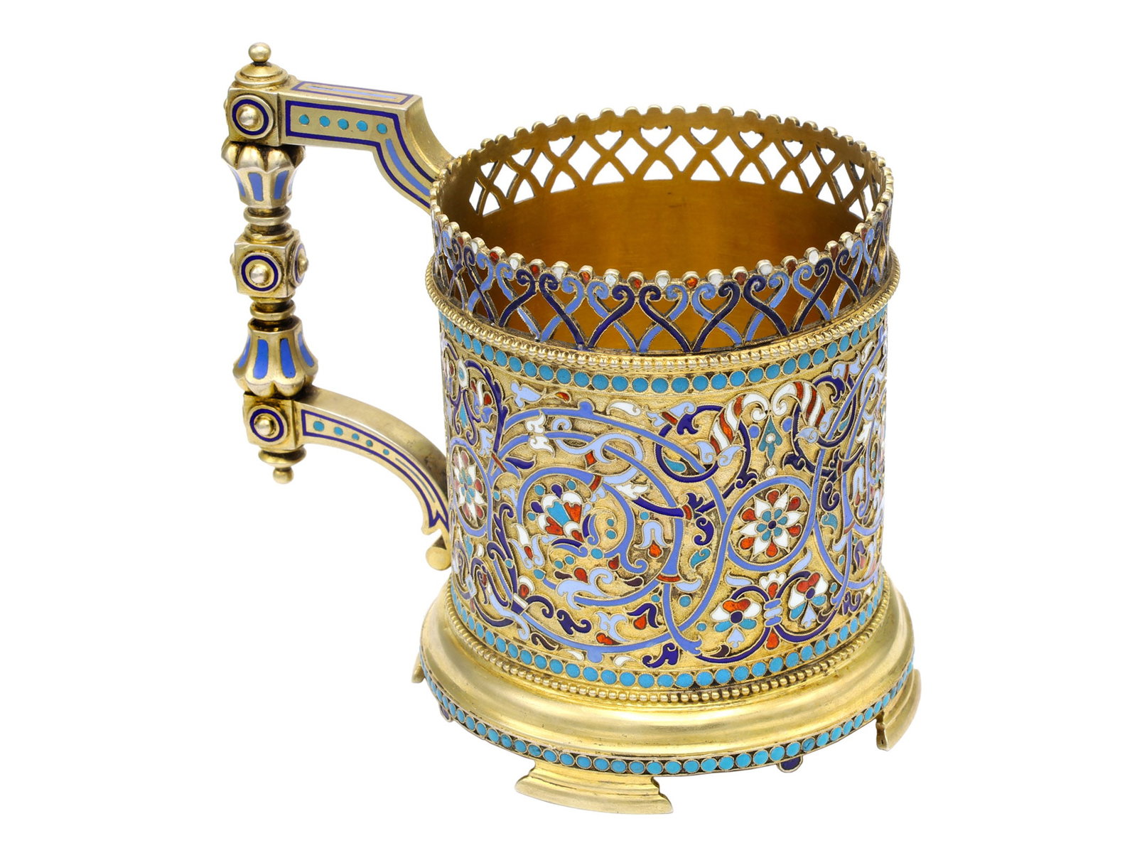 A RUSSIAN GILT-SILVER AND CLOISONNE ENAMEL TEA GLASS HOLDER BY KLINGERT: Gustav Klingert, Moscow, 1899. Of cylindrical form on a spreading circular base raised on bracket feet. The body is richly decorated with scrolling foliage, palmettes and floral rosettes in blue, turq