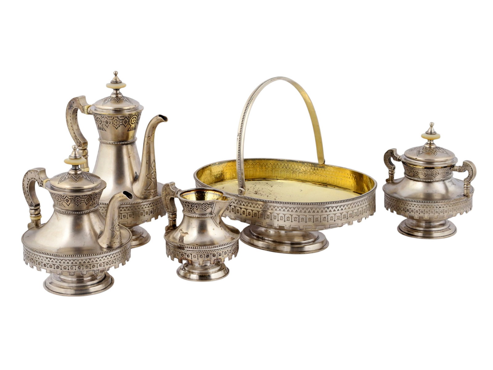 A RUSSIAN SILVER AND PARCEL-GILT PAN-SLAVIC FIVE-PIECE TEA AND COFFEE SERVICE, MOSCOW, 1880: Comprising a teapot, coffee pot, lidded sugar bowl, cream jug, and bread basket, each with a parcel-gilt interior and raised on a stepped circular foot. The bodies are decorated in the Old Russian sty