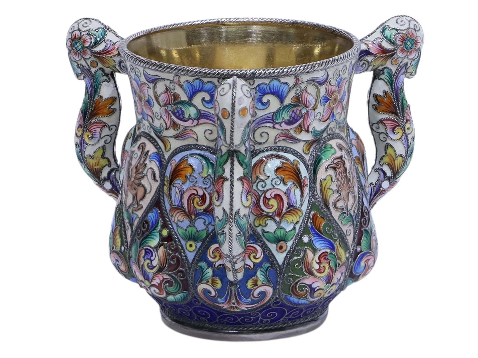 A RUSSIAN SILVER AND ENAMEL CUP BY F. RUCKERT, MOSCOW, 1899-1908: Of baluster form, the lower section with lobed cartouches enameled with shaded, varicolored stylized floral sprays within twisted ropework borders, the upper section enameled with griffins and shaded,