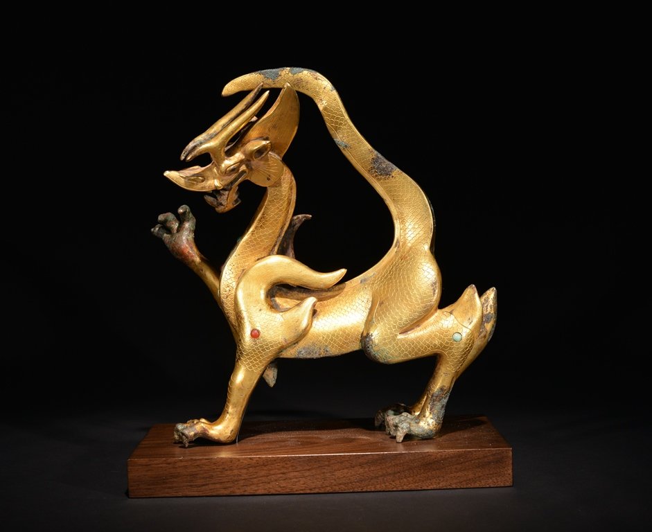 A GILT-BRONZE BEAST: It is four-legged beast and overall golden color tone. 9 11/16 in. (24.5 cm) tall, 9 1/2 in. (24.1 cm) long. Han Dynasty