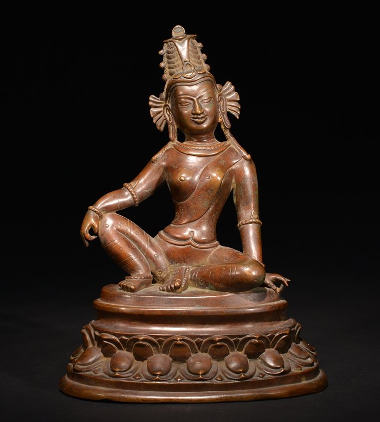 A BRONZE FIGURE OF GUANYIN: The carving is a half seated holy figure on a double lotus base and wearing a tall crown. 9 9/16 in. (24.3 cm) tall. 15-16th Century