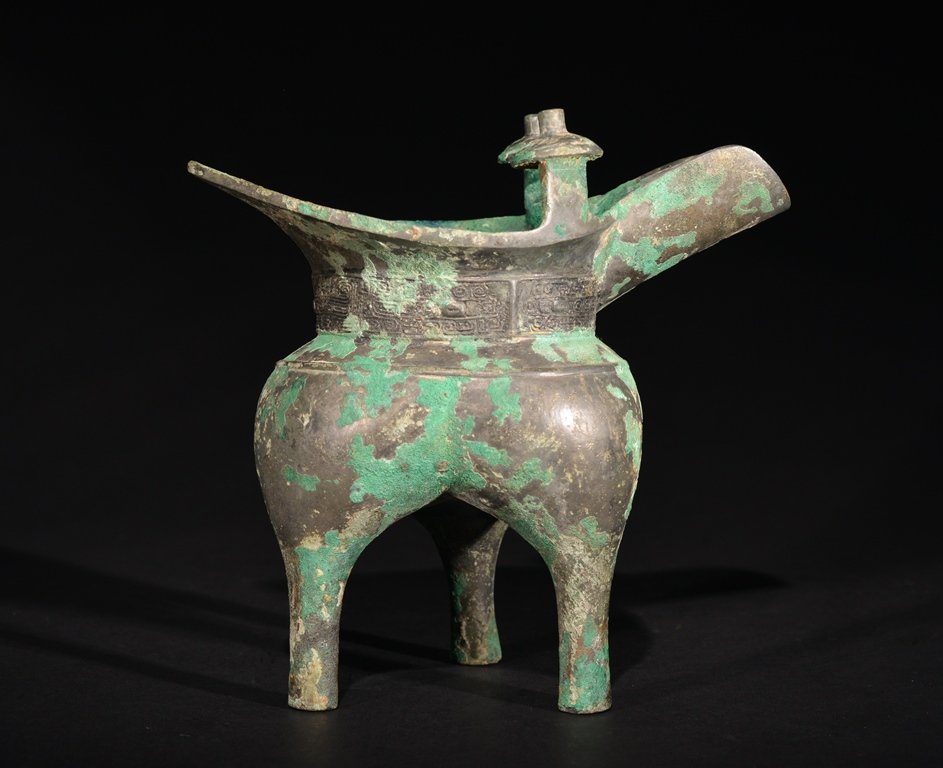 A BRONZE RITUAL WINE VESSEL: The vessel has a tripod legs and overall a imperial designs. 7 1/2 in. (19.1 cm) tall, 7 9/16 in. (19.3 cm) wide. Shang Dynasty