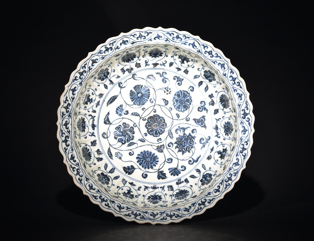 A LAREG BLUE AND WHITE DISH: The dish is concave-shaped and the interior is decorated with numerous flower blossoms. 3 1/2 in. (8.9 cm) tall, 16 1/2 in. (42 cm) diameter. Ming Dynasty